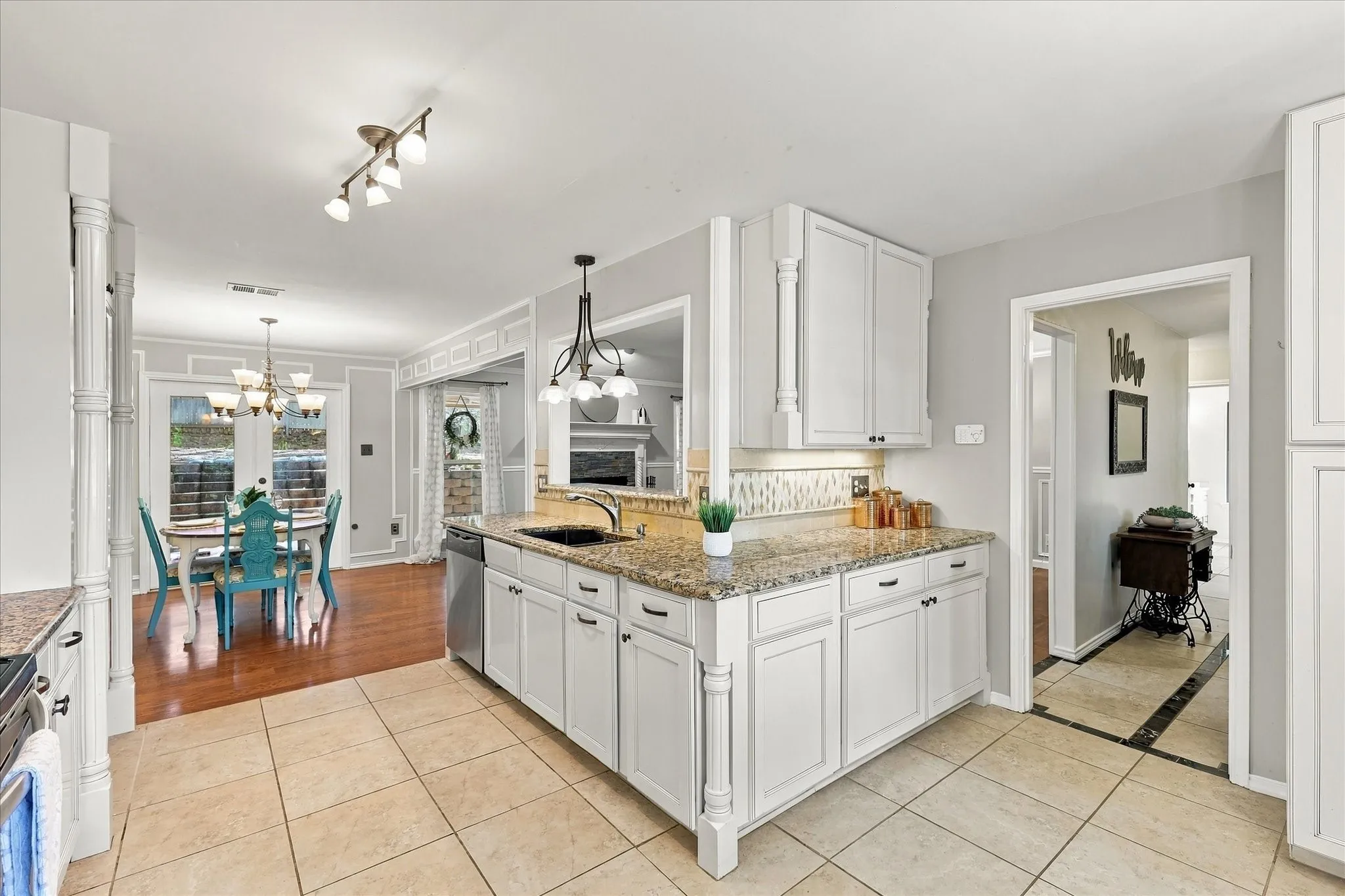 Kitchen featuring white cabinetry, granite countertops, tile flooring, and a stainless steel dishwasher