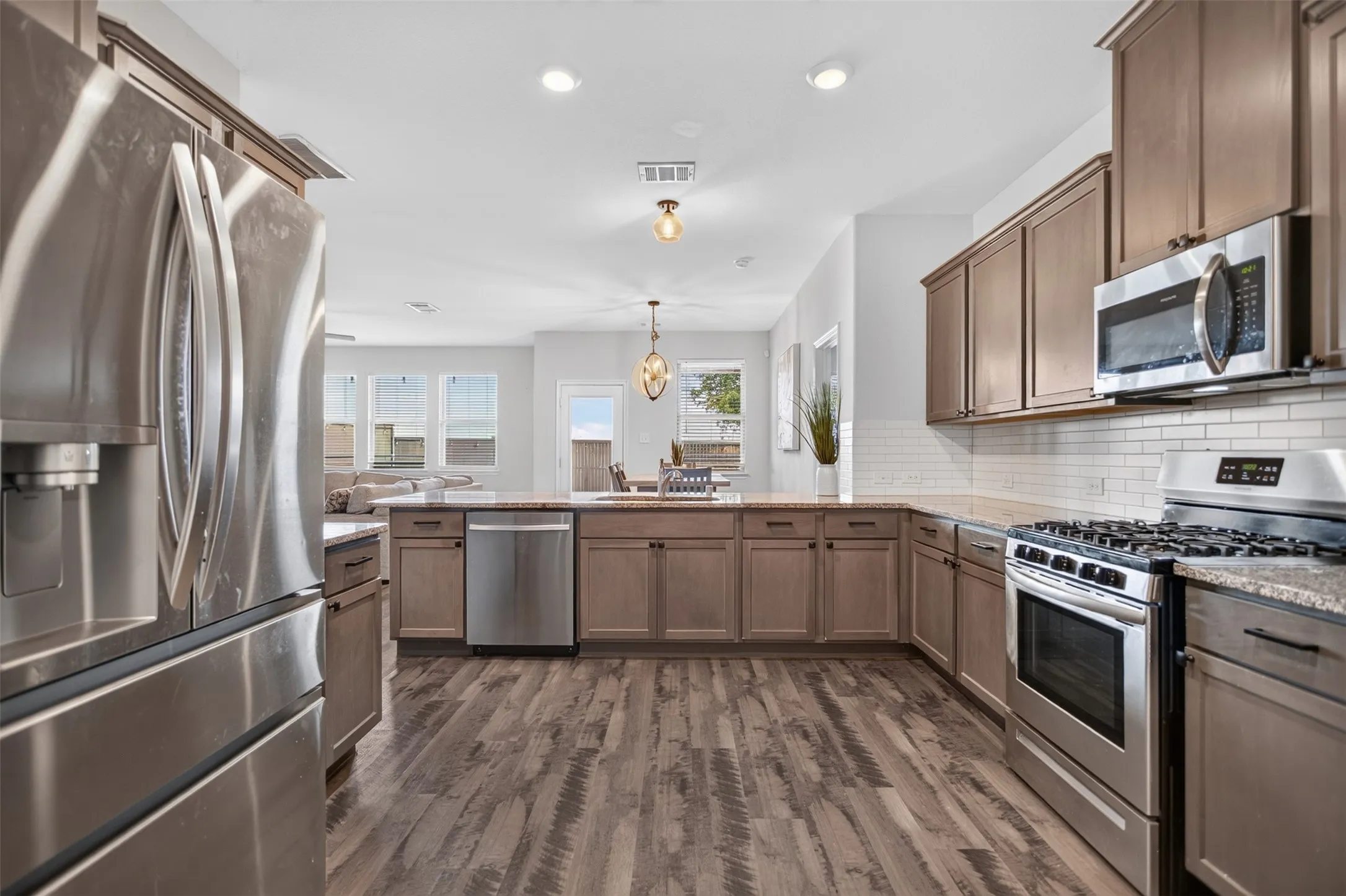 Kitchen boasts of plenty of granite counter space and cabinets, gas range, and stainless steel appliances