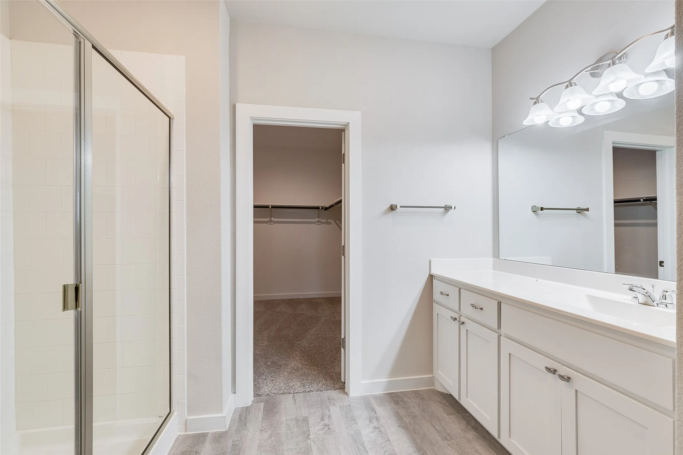 Walk-in shower with clear glass enclosure and tile surround