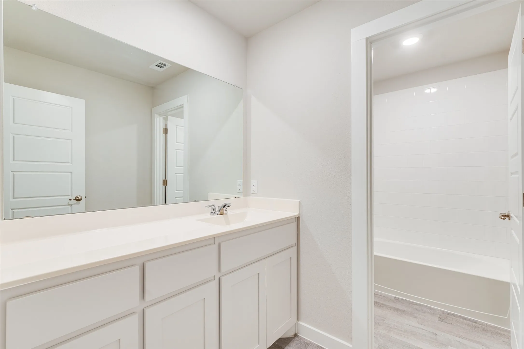 Expansive vanity with an integrated sink, polished chrome faucet, and full-width mirror