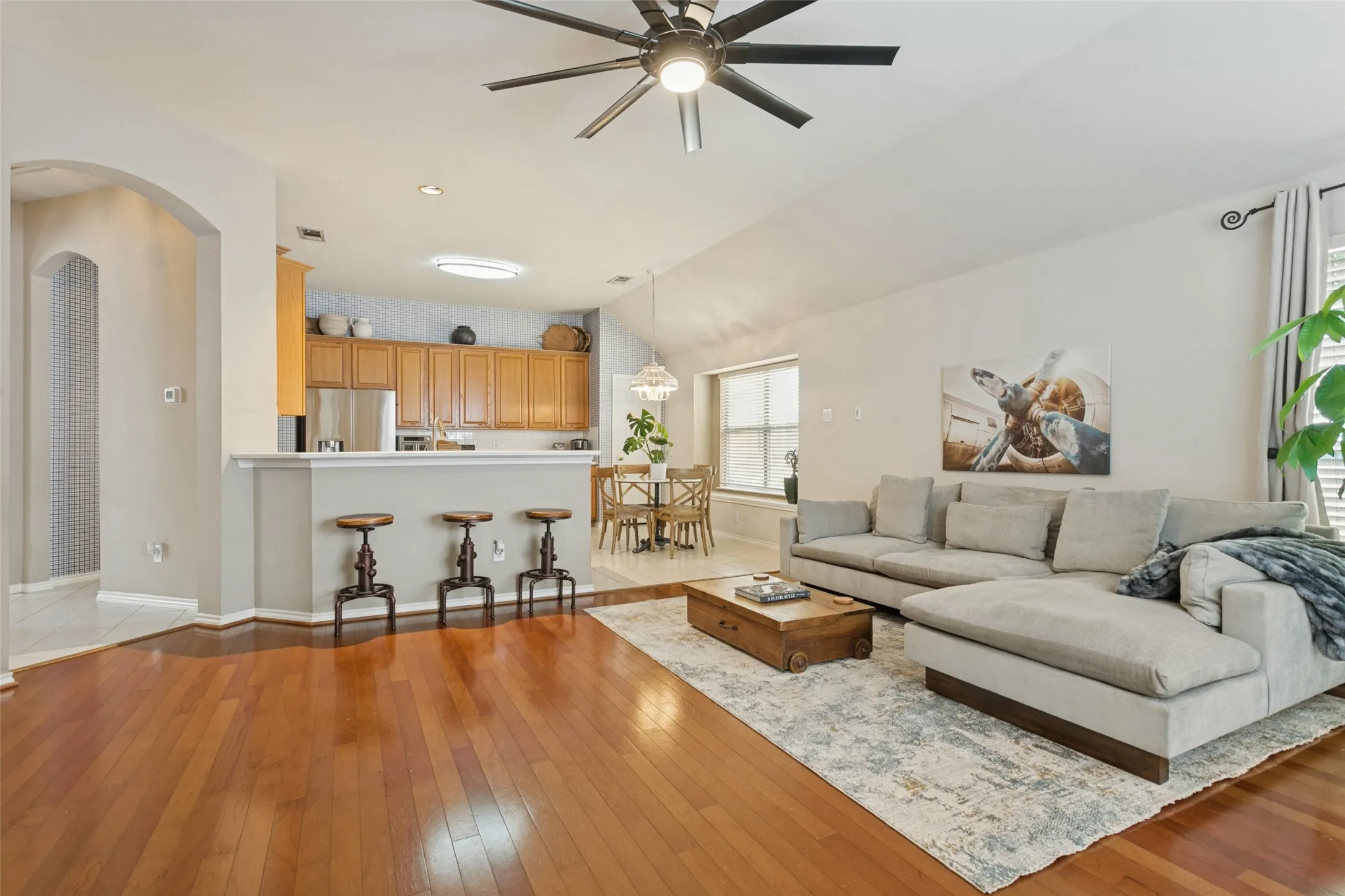 Wood-finish flooring, vaulted ceiling, and an arched entryway
