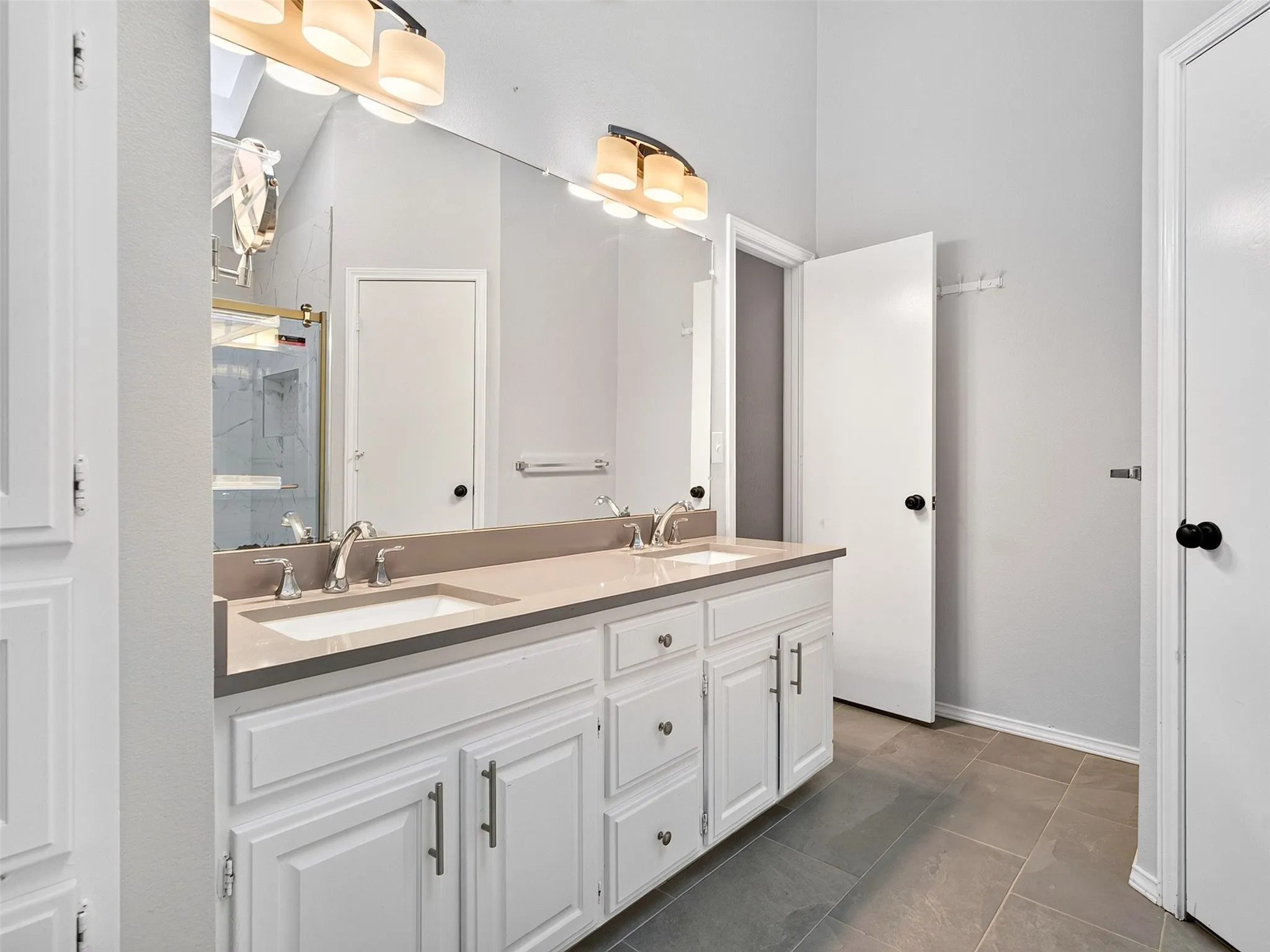 Dual vanity with undermount sinks, white cabinetry, and brushed nickel hardware
