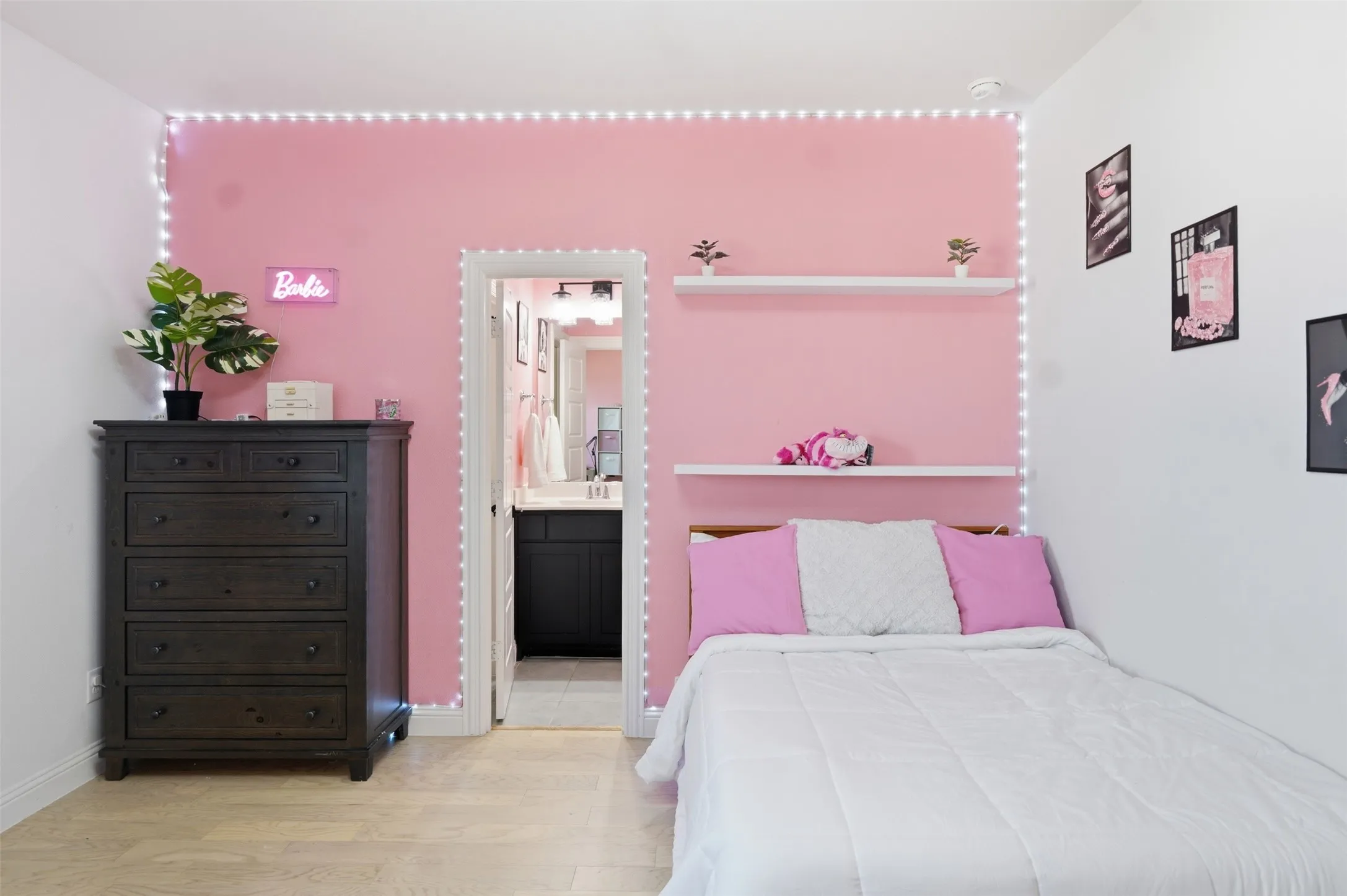 Bedroom 5 with ensuite - Hardwood-style flooring, built-in wall shelving, and a bright interior with a recessed doorway