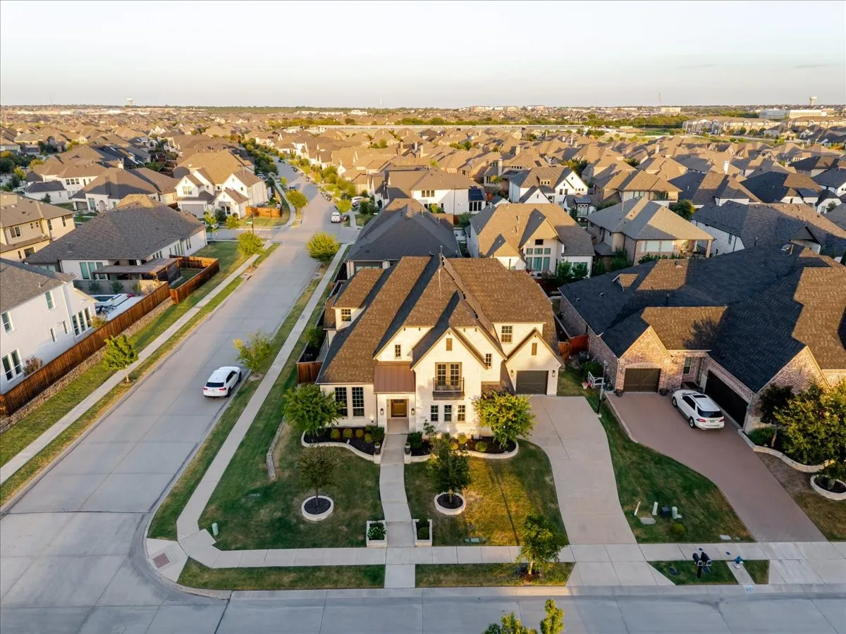Craftsman-style exterior with stone and siding accents, featuring a multi-car garage, established landscaping, and a corner lot