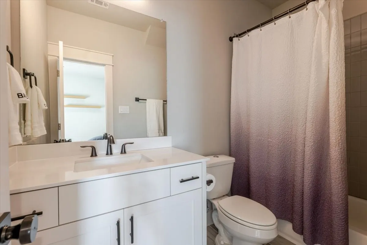 White vanity with black hardware, integrated sink, and dark bronze-finish faucet
