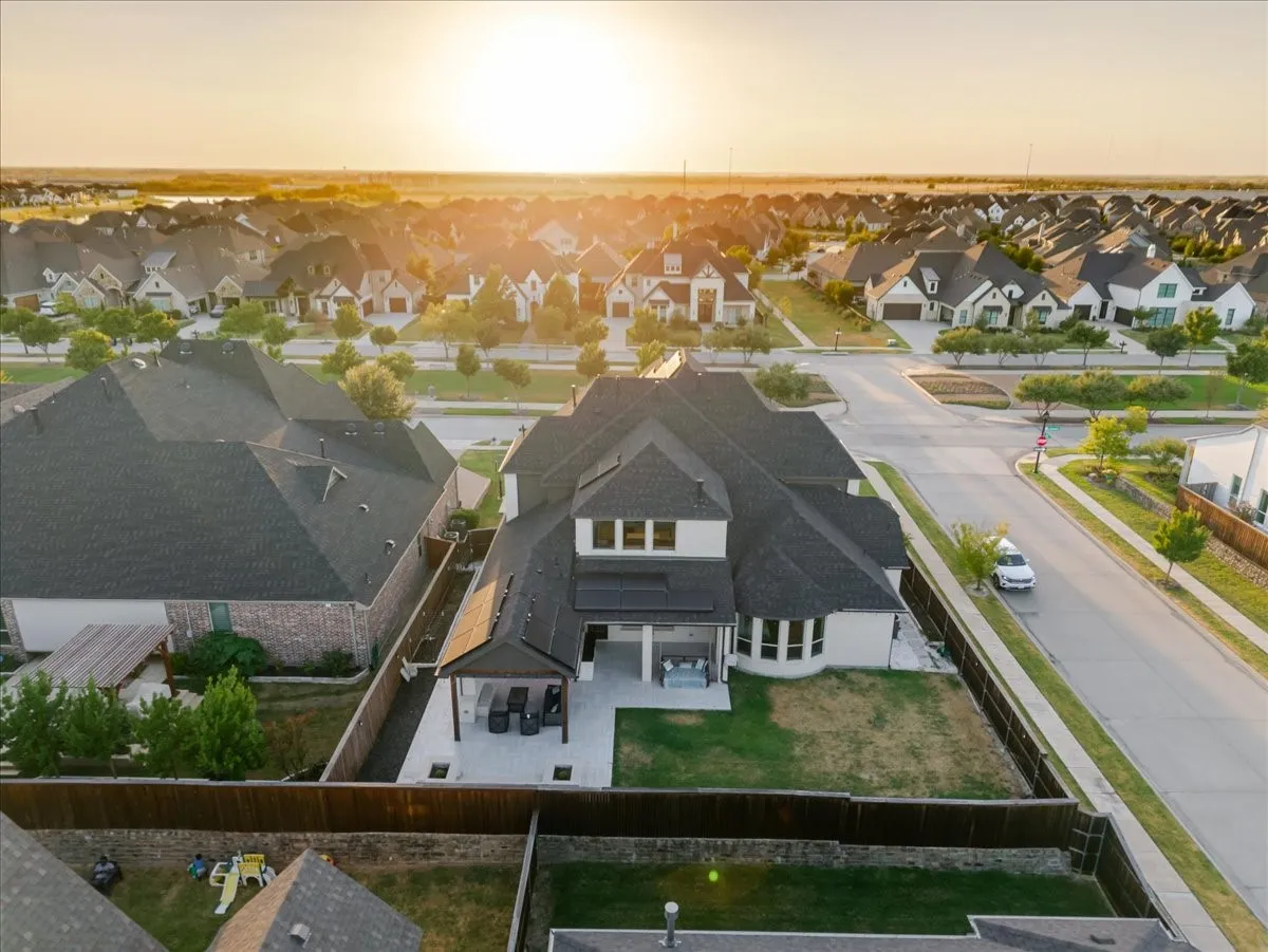 Expansive backyard featuring a covered patio, paved outdoor living area, and a privacy fence