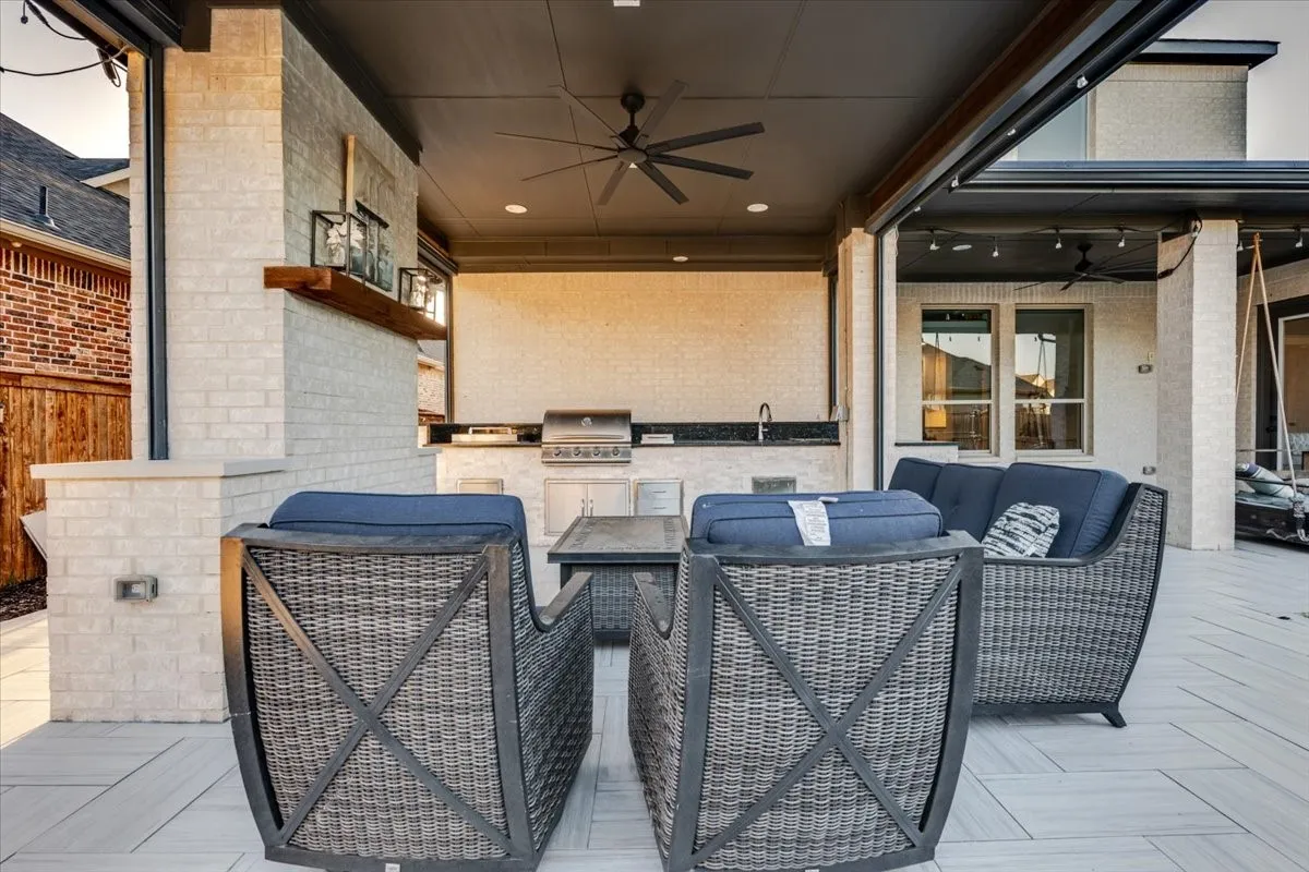 Covered patio with a built-in outdoor kitchen, recessed lighting, ceiling fan, and tiled flooring