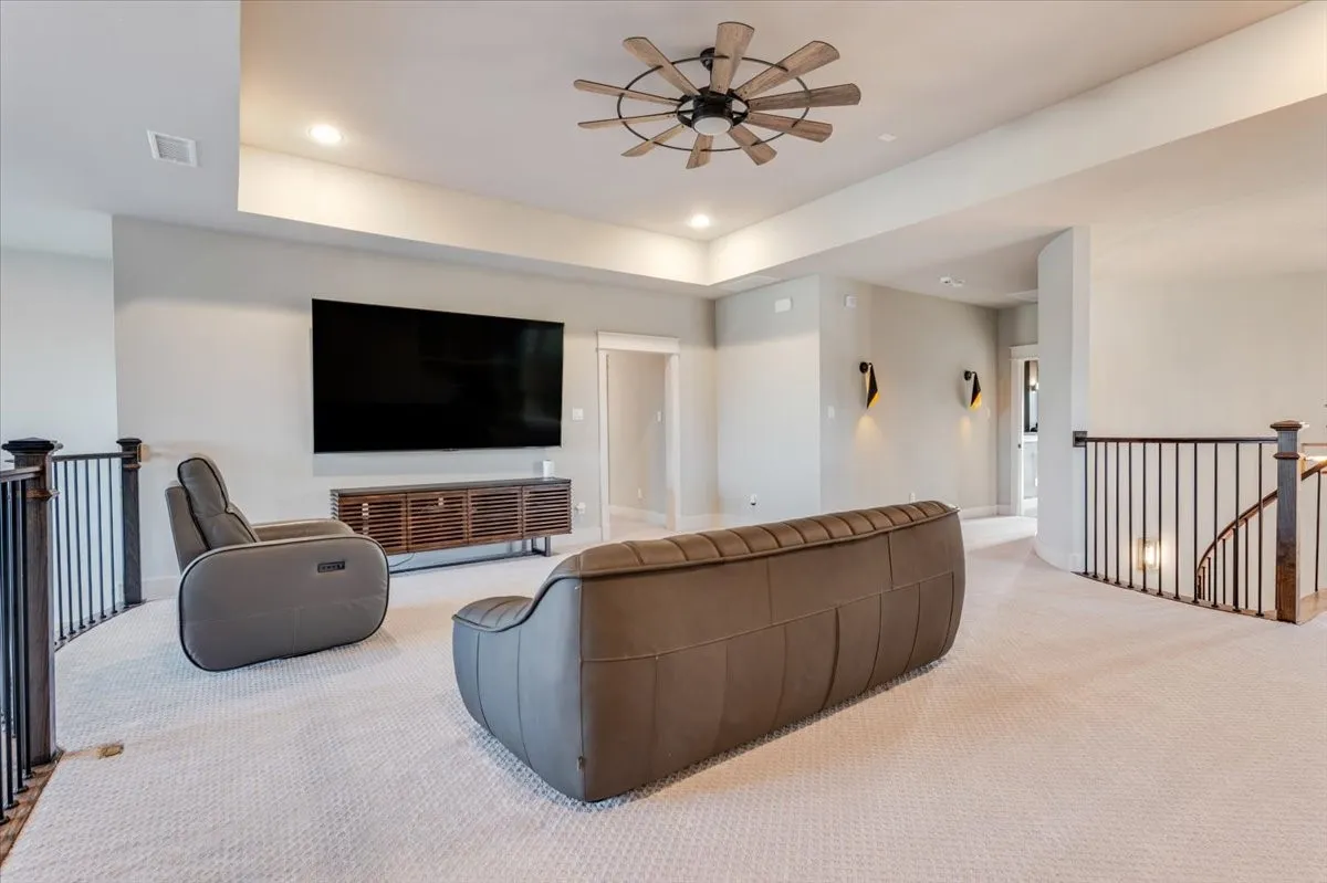 Tray ceiling, recessed lighting, ceiling fan, and iron balusters
