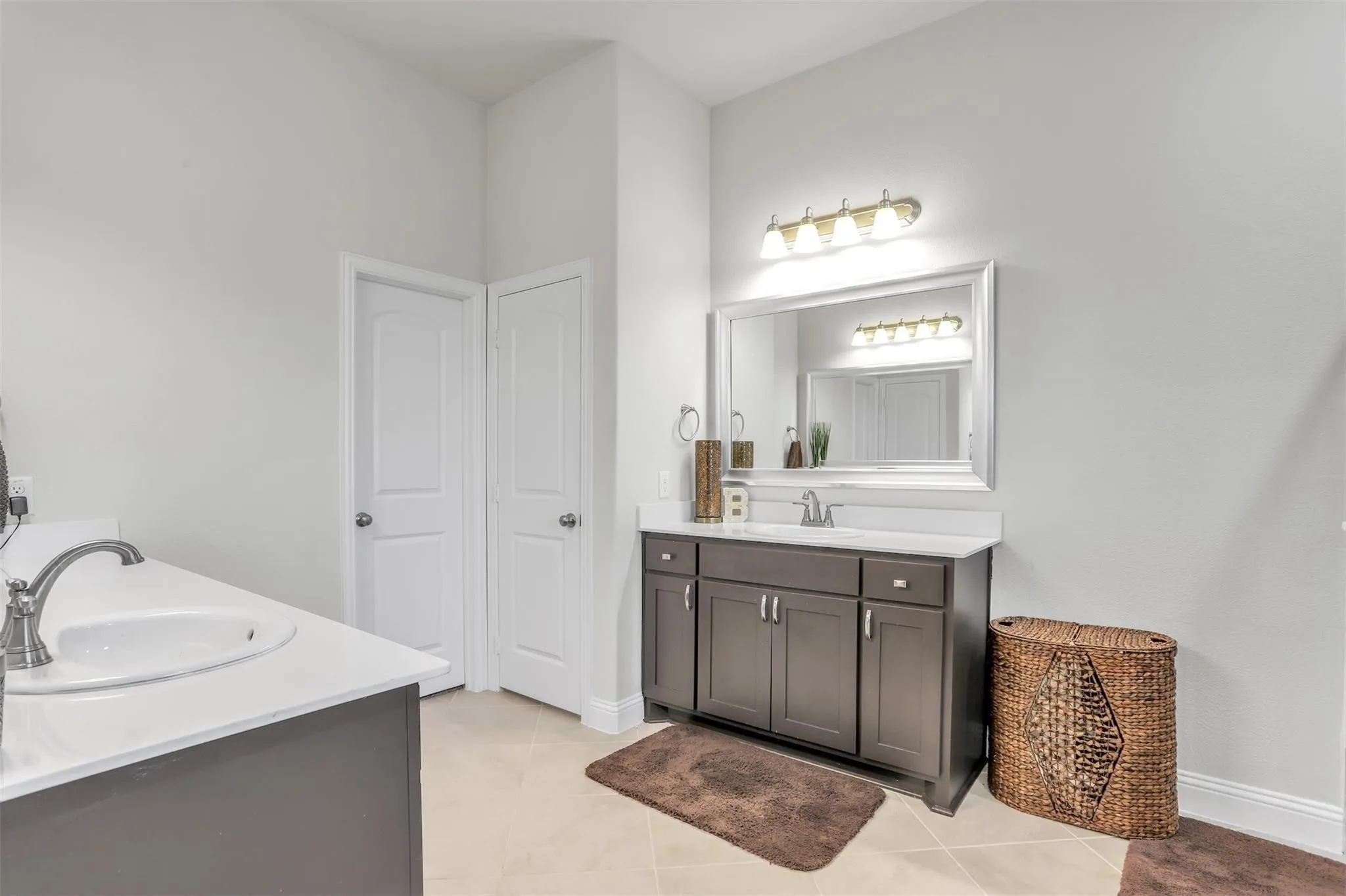 Dual vanity with white countertops, undermount sinks, and brushed nickel fixtures