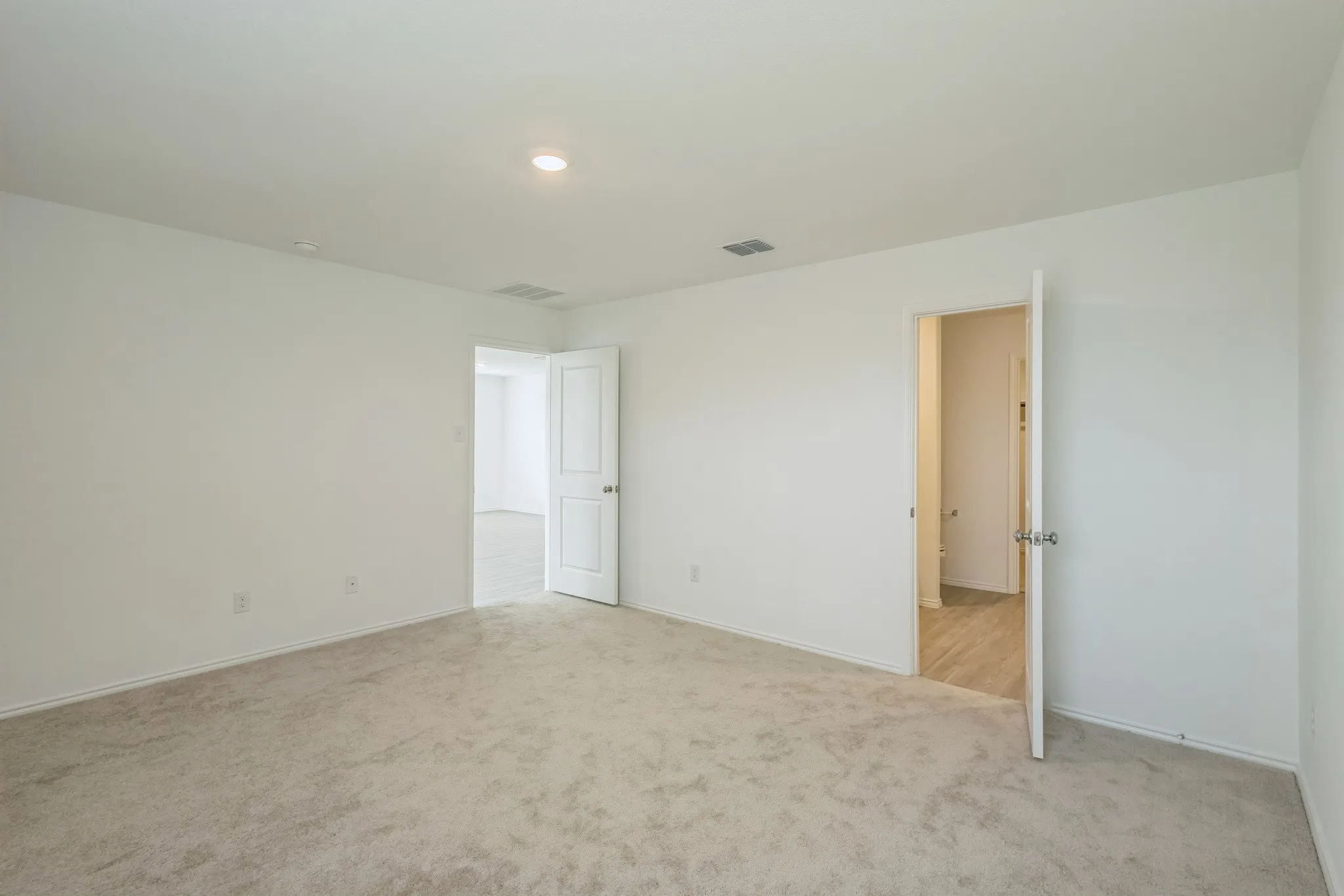 Neutral-toned carpeting, white walls, and recessed lighting