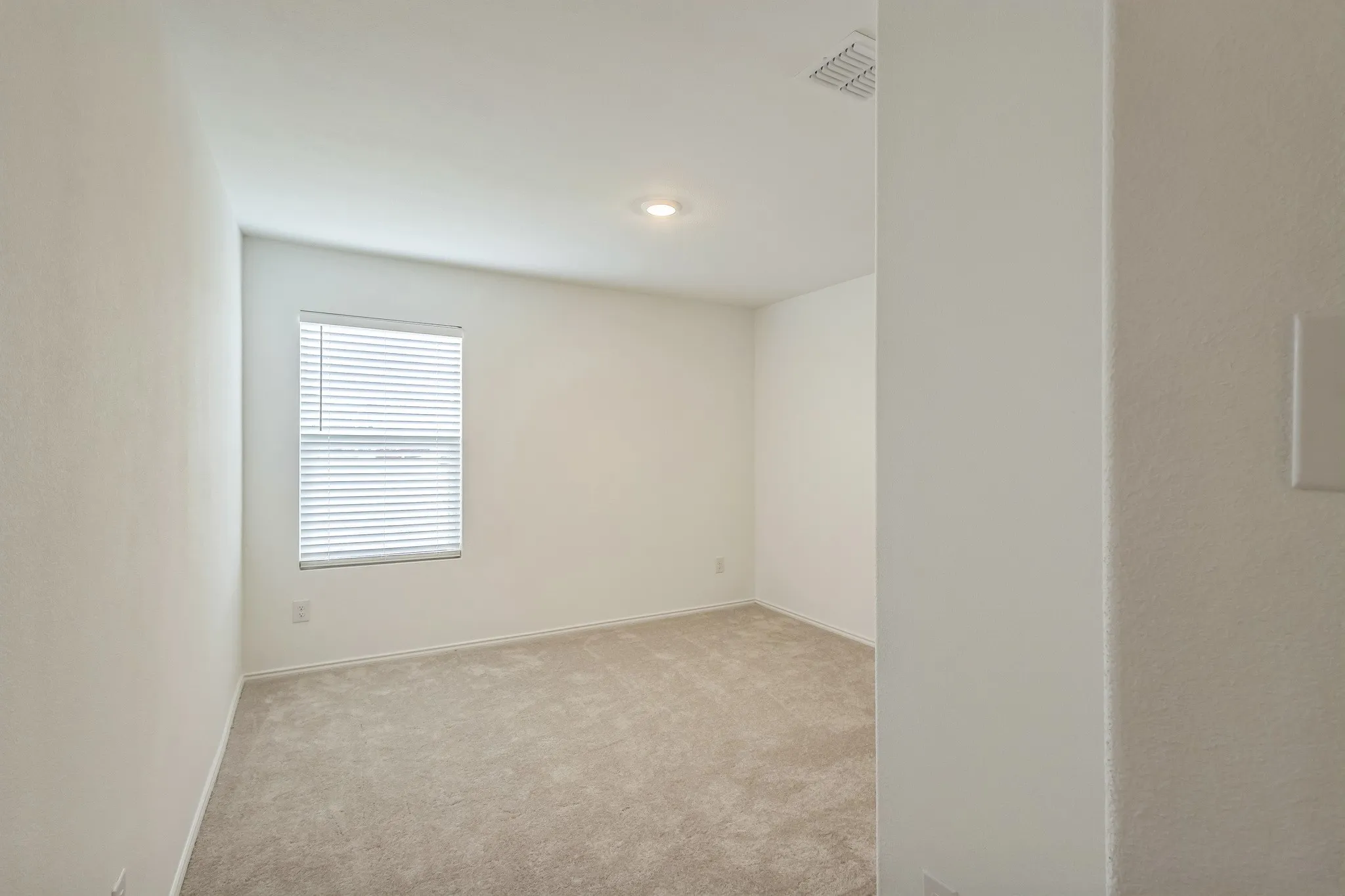 Recessed lighting, neutral wall finishes, window with blinds, and carpeting