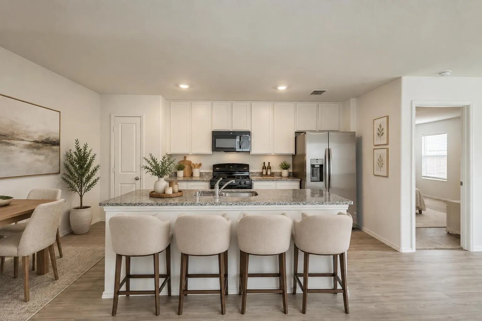 Kitchen featuring an island with stone countertop, white cabinetry, stainless steel appliances, and wood-finish flooring