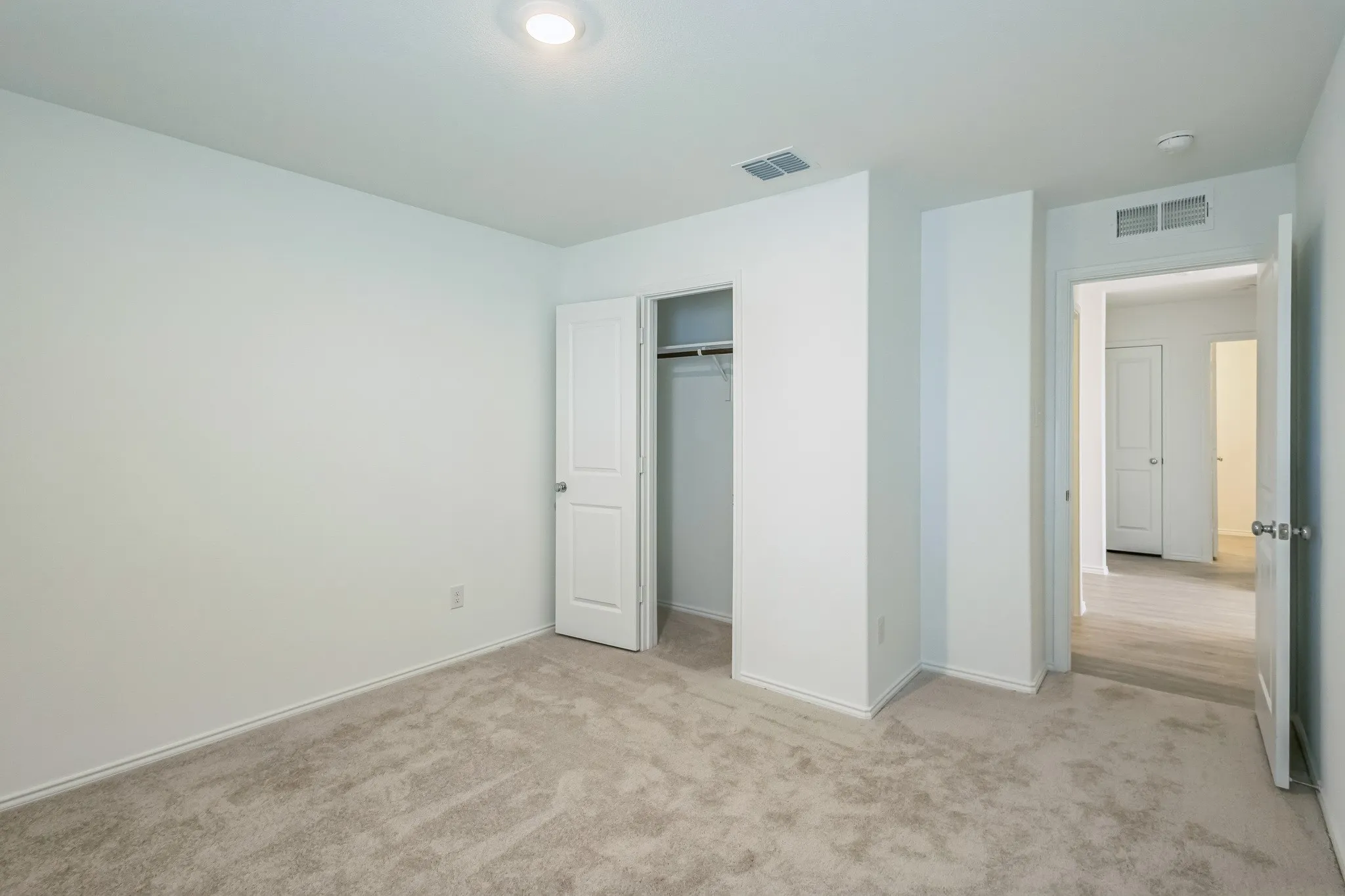 Plush carpeted flooring, a recessed ceiling light, and a built-in closet with a panel door