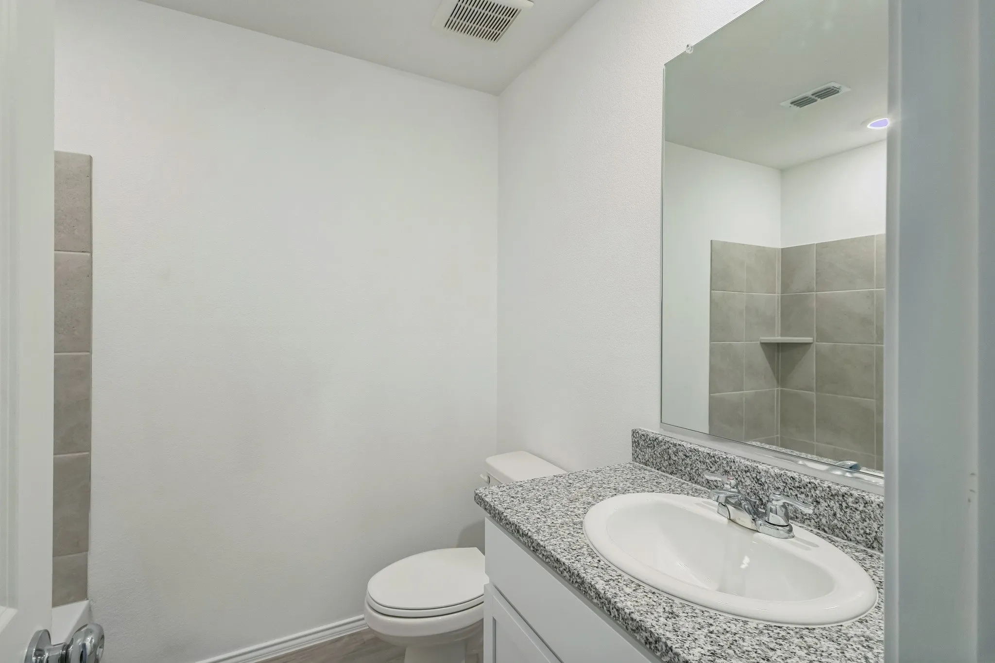 Vanity with speckled countertop, undermount sink, and chrome faucet