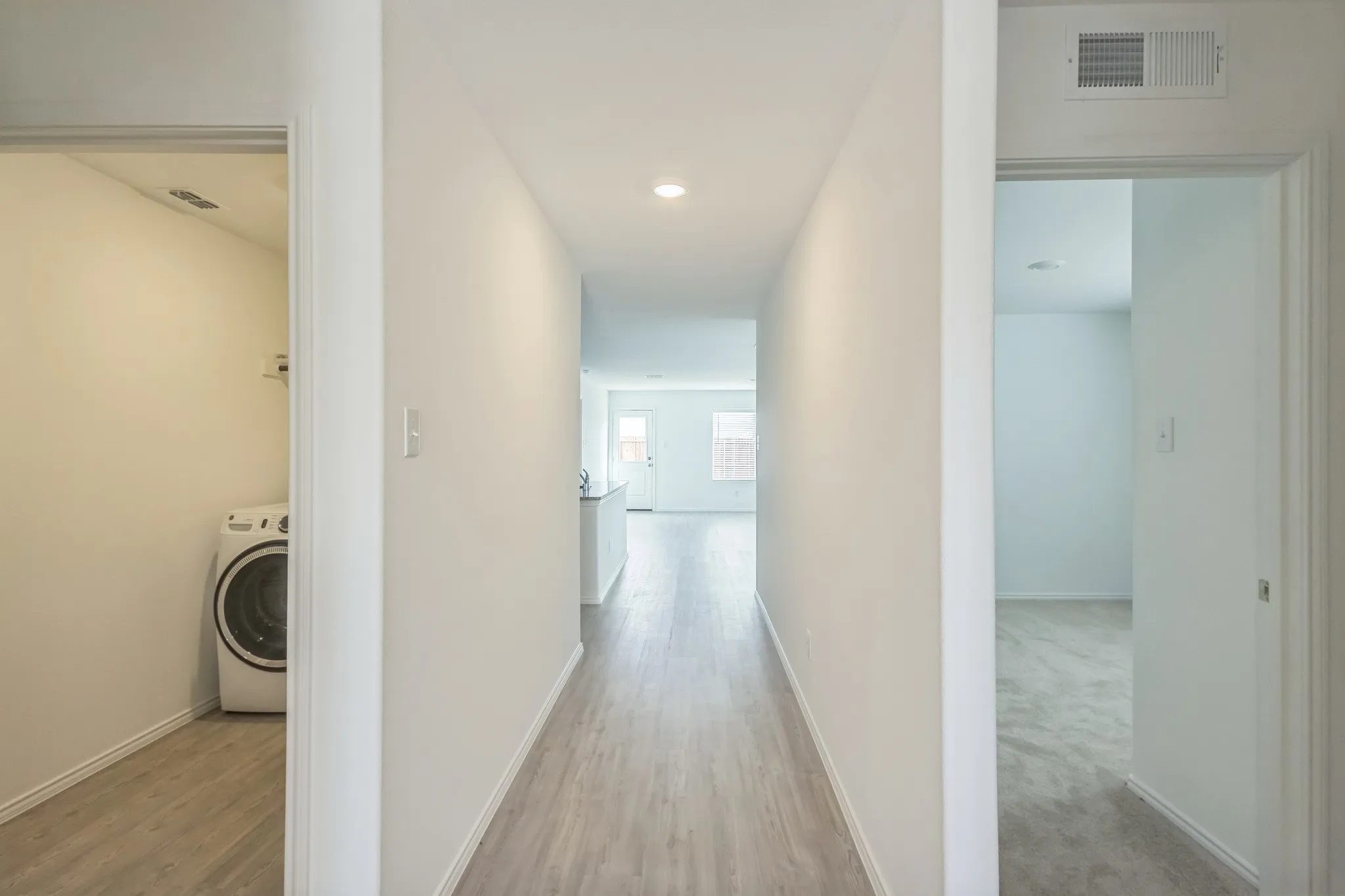 Hallway with wood-finish flooring, recessed lighting, and white walls