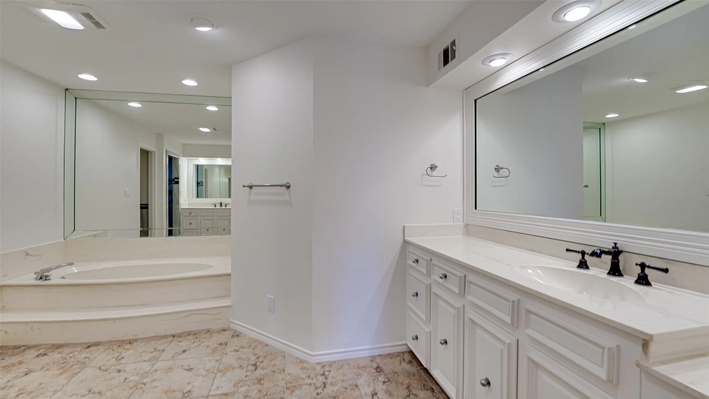 Bathroom with vanity, tile patterned flooring, and a tub