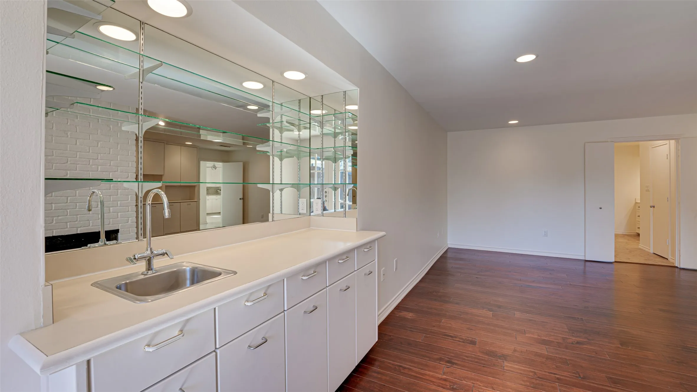 Primary bedroom featuring a coffee bar area and/or office nook, white cabinets, and dark hardwood / wood-style floors