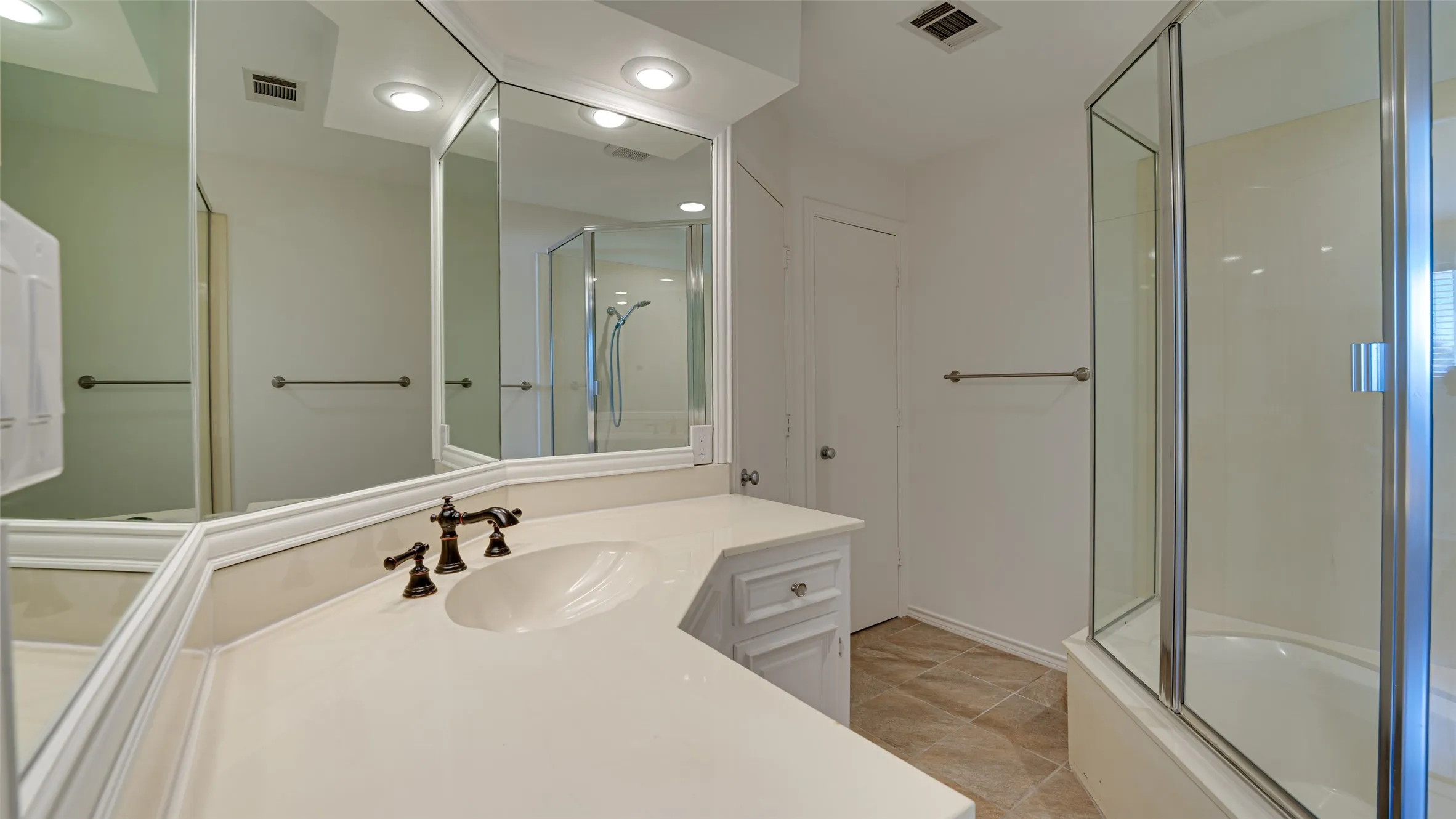 Bathroom with vanity, tile patterned flooring, and enclosed tub / shower combo