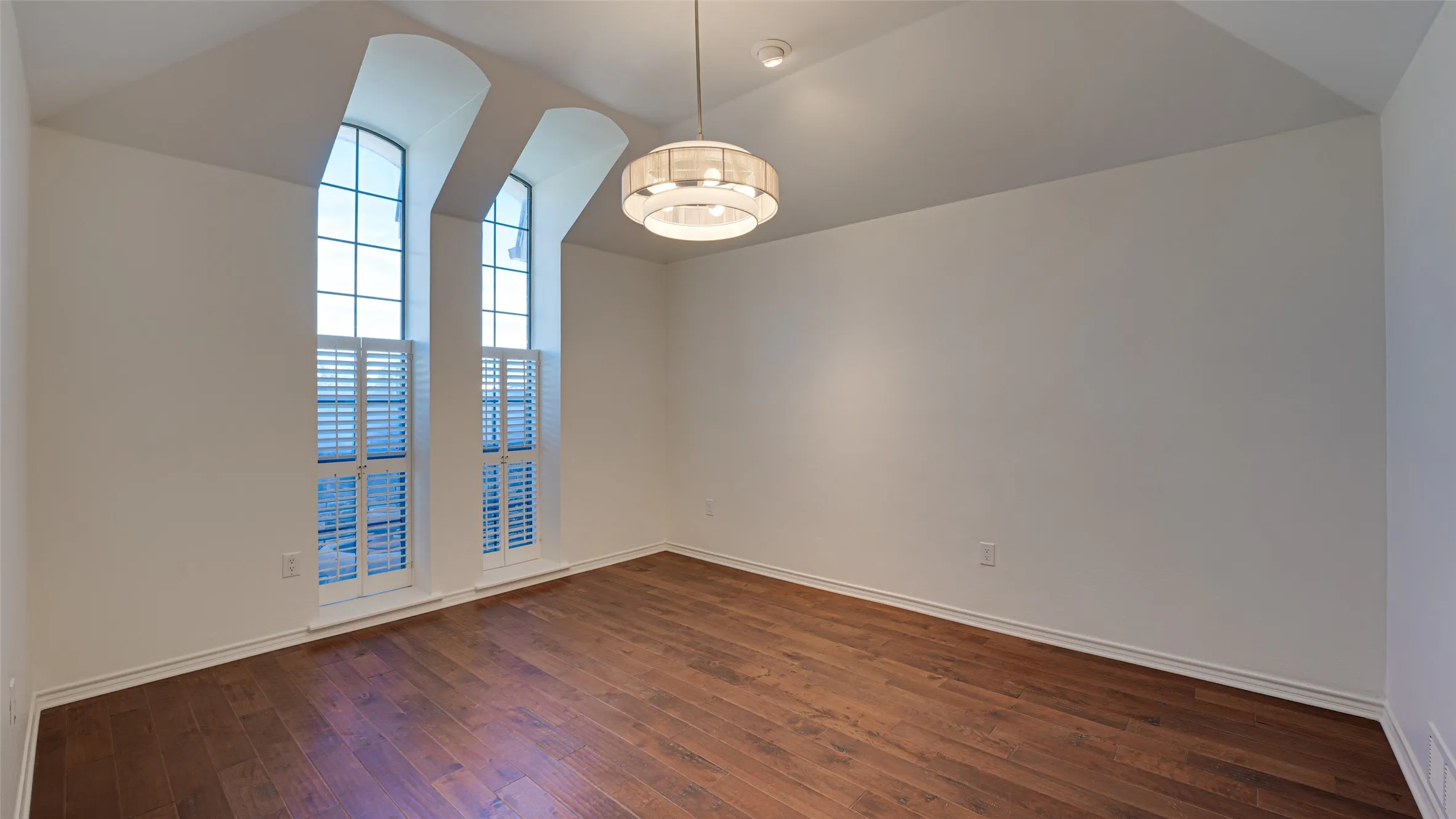 Dining room featuring wood-type flooring and lofted ceiling