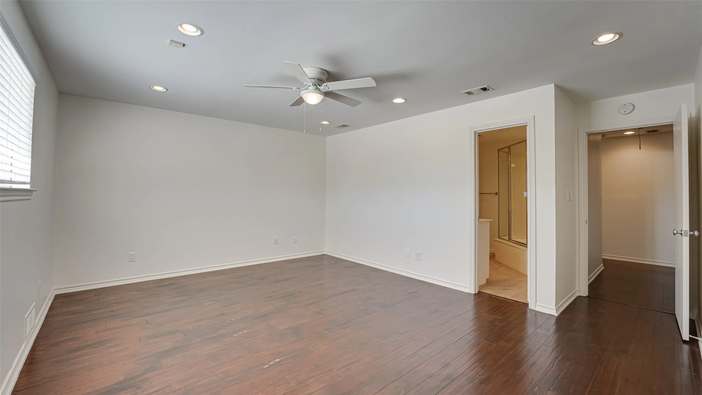 Unfurnished bedroom featuring ensuite bath, ceiling fan, hardwood / wood-style flooring, and a closet