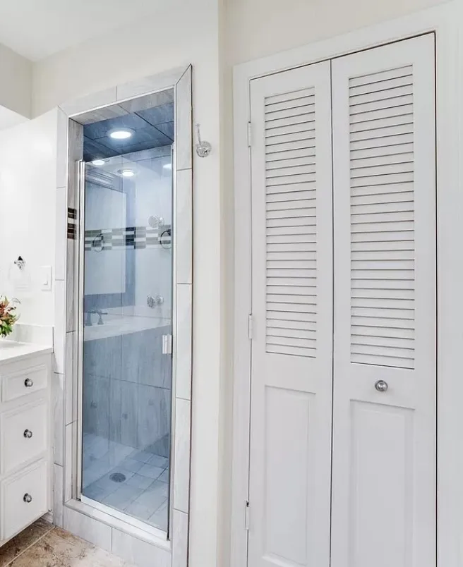 Bathroom with vanity, a shower with door, and tile patterned flooring