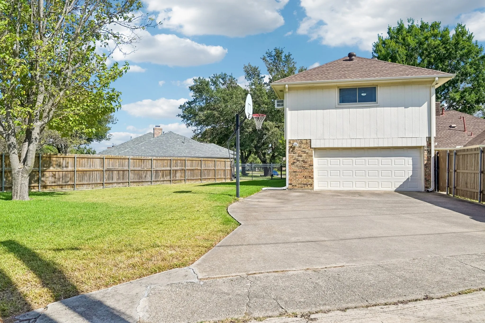 Two-story property featuring a white paneled exterior, brick veneer accents, and an attached two-car garage