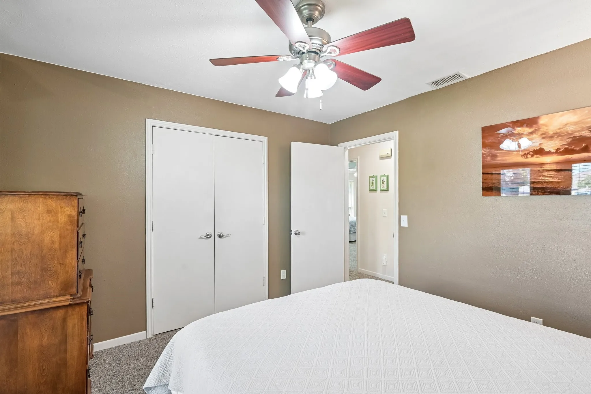 Ceiling fan with light fixture, neutral wall finishes, and gray carpet flooring