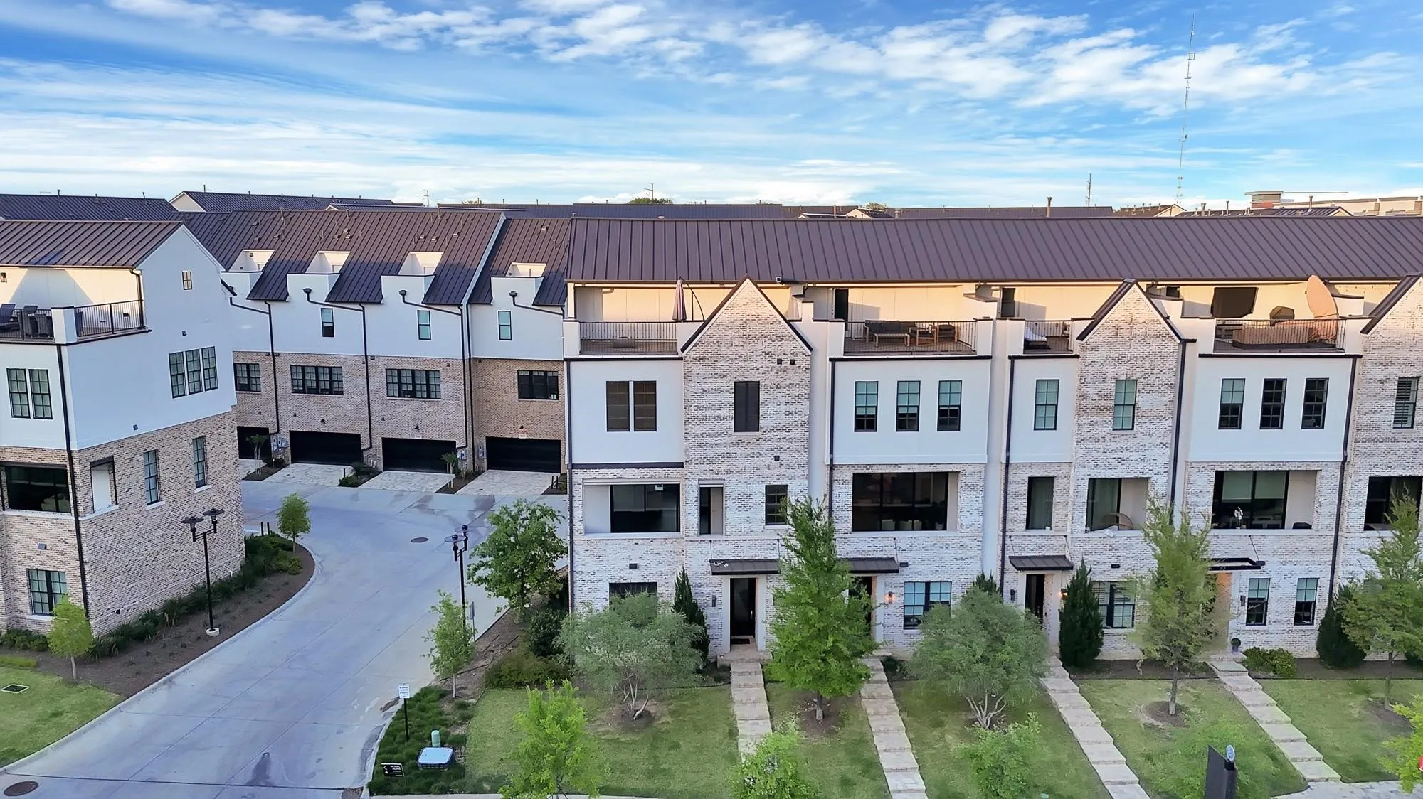 Modern townhome exteriors featuring light-colored brick and white siding