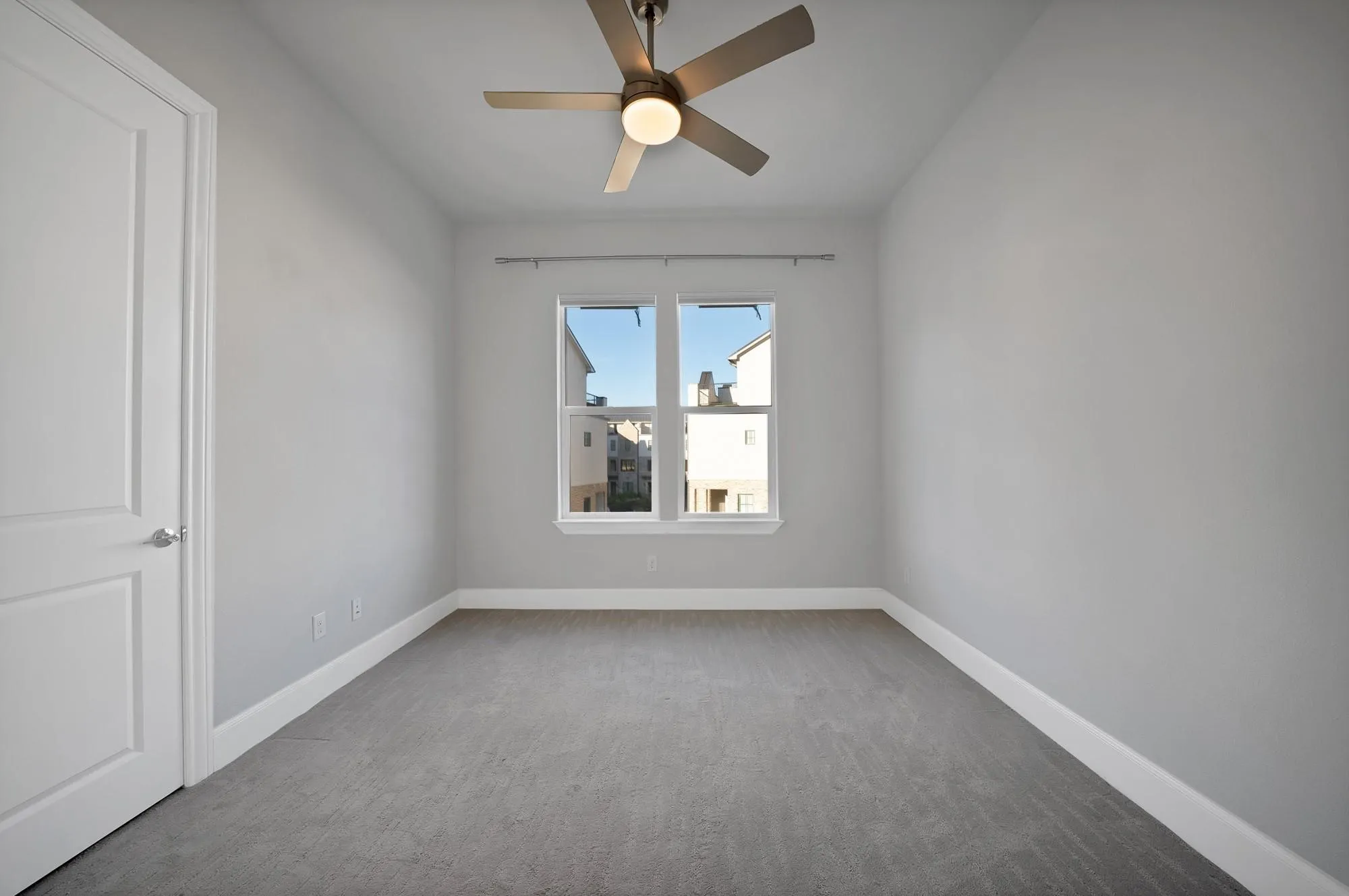 Recessed window with white trim, a flush-mount ceiling fan with integrated lighting, and neutral-toned wall-to-wall carpeting