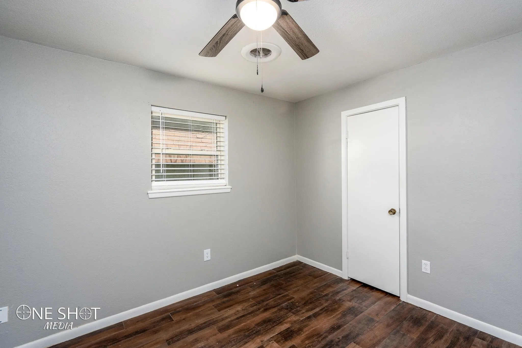 Empty room featuring ceiling fan and dark wood-type flooring