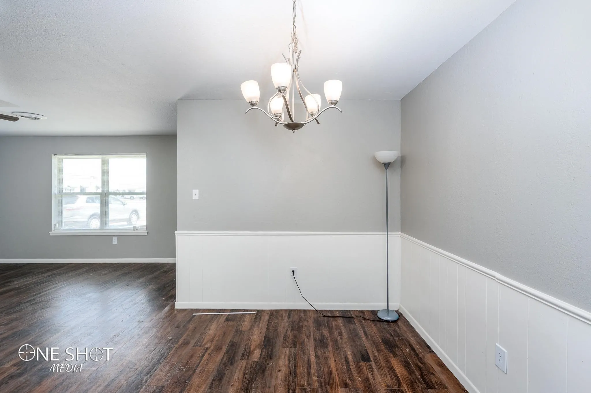 Spare room featuring dark hardwood / wood-style flooring and a notable chandelier