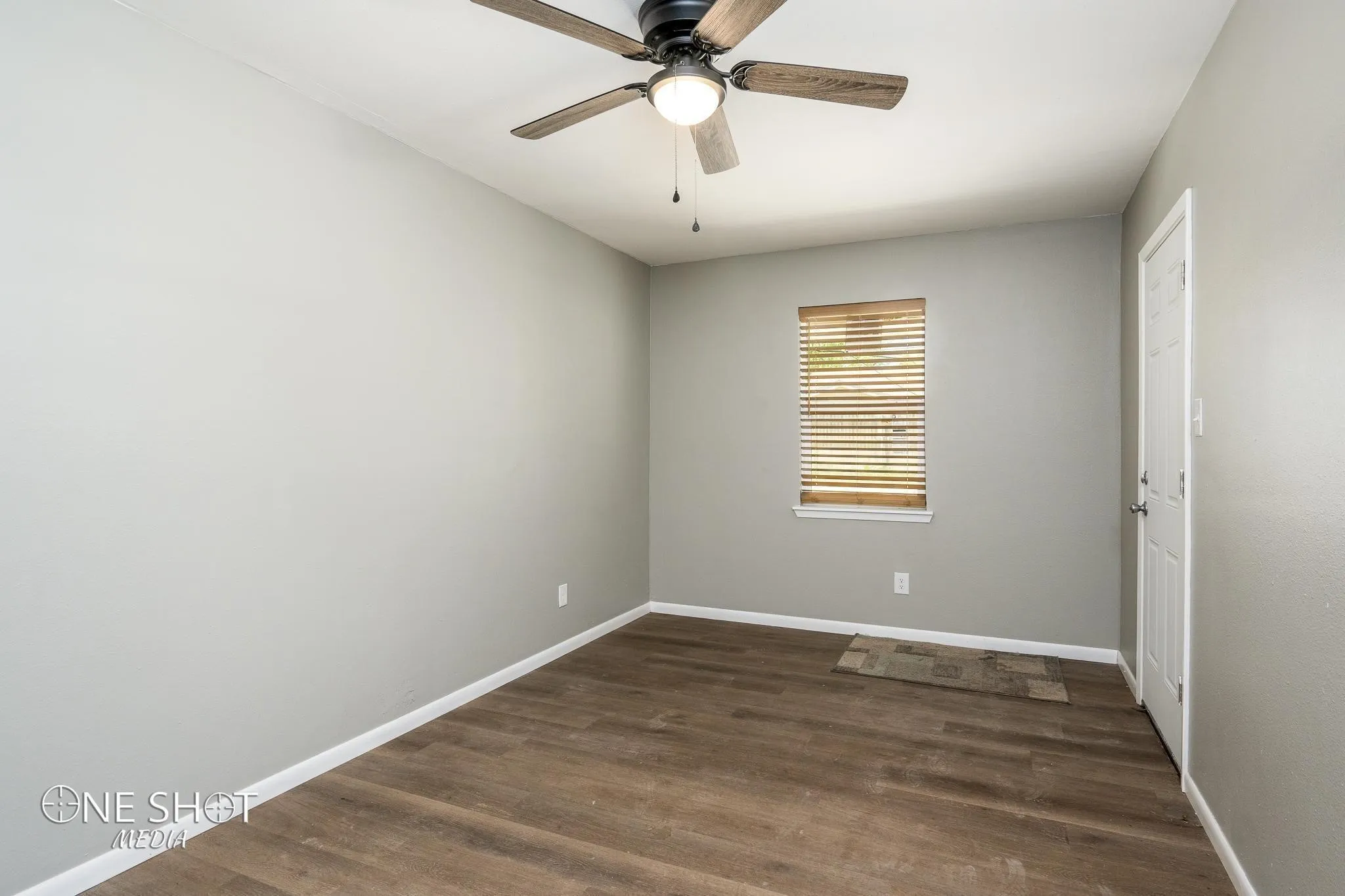 Empty room featuring dark hardwood / wood-style floors and ceiling fan