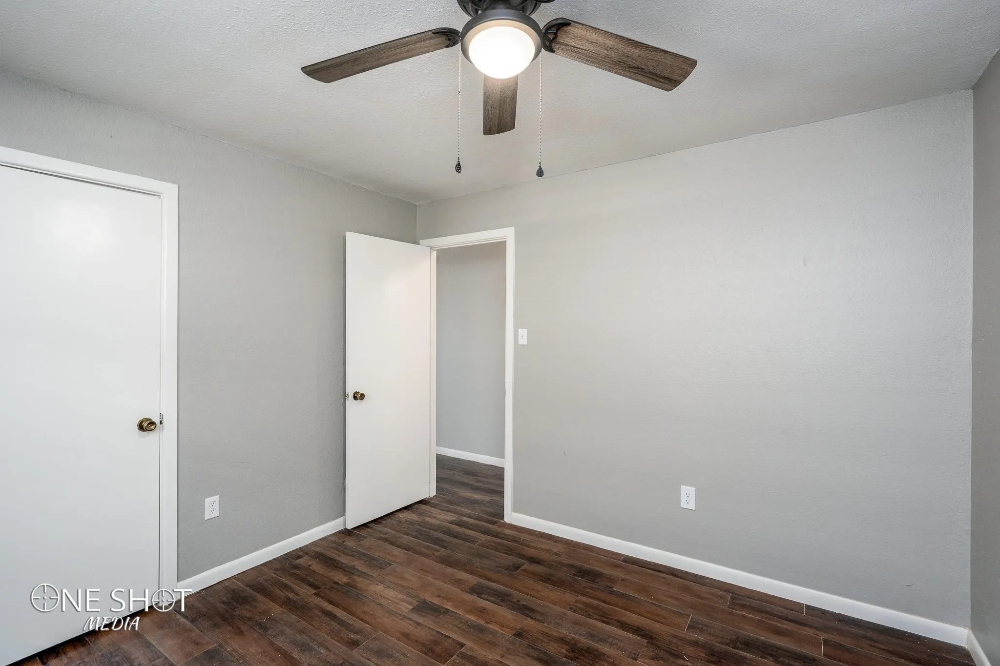 Unfurnished bedroom with dark hardwood / wood-style flooring and ceiling fan
