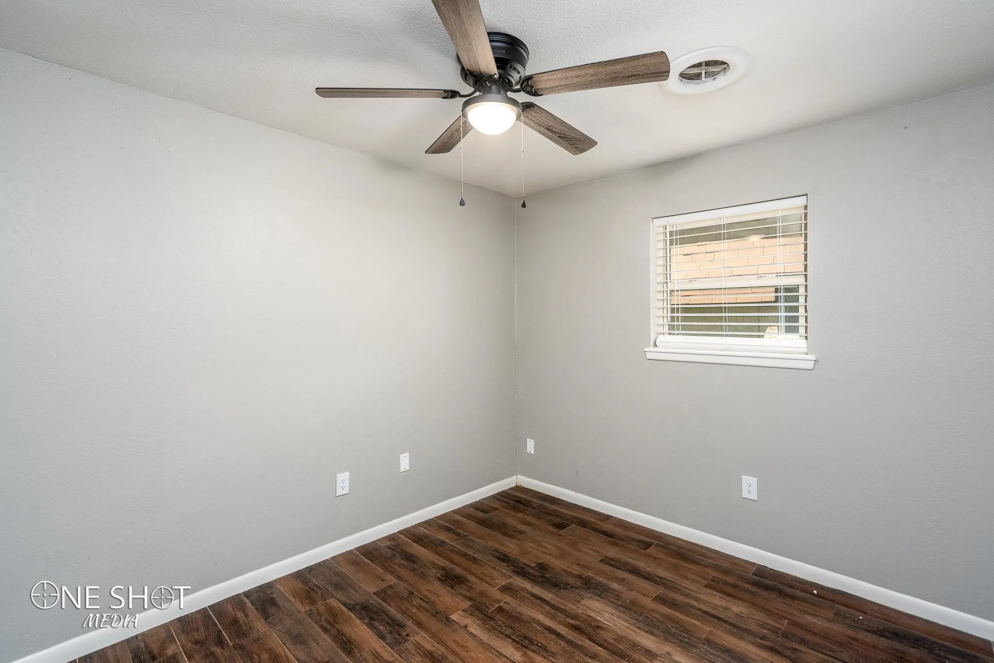 Unfurnished room with ceiling fan and dark wood-type flooring