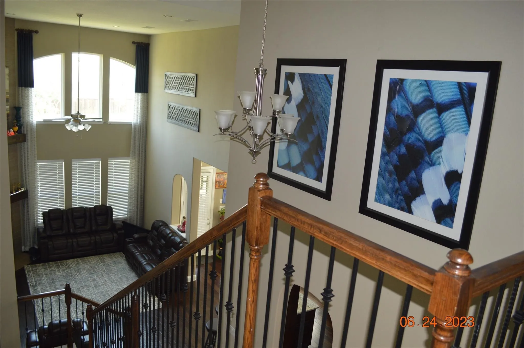 Stairs with a chandelier and a ceiling fan