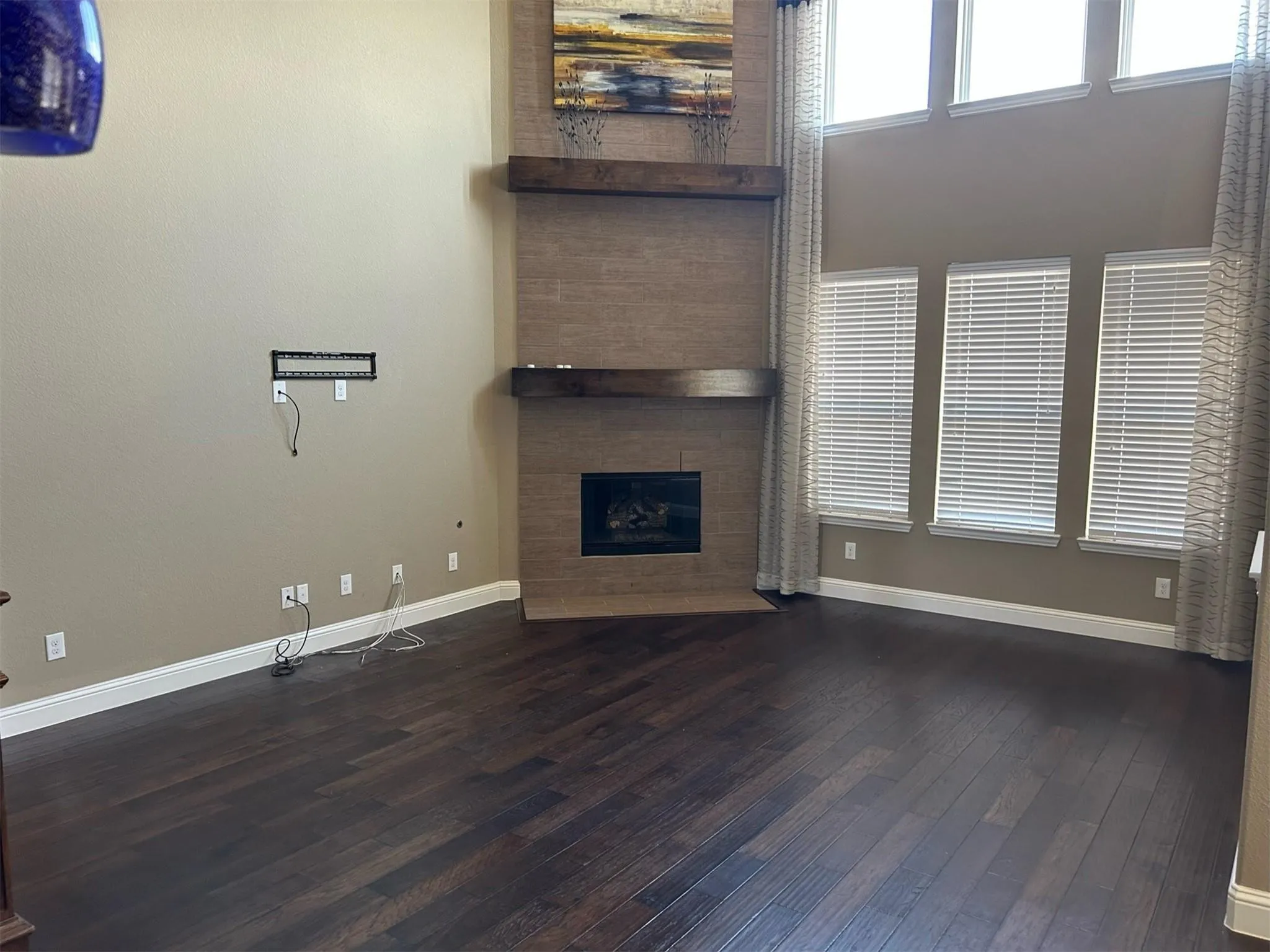 Unfurnished living room featuring dark wood-type flooring and a fireplace