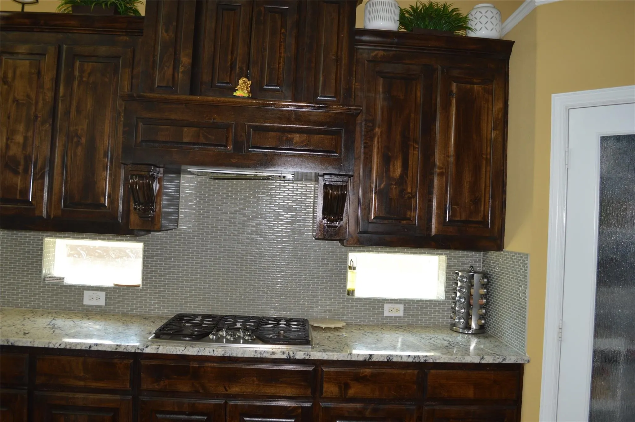 Kitchen featuring backsplash, dark brown cabinetry, and stainless steel gas cooktop