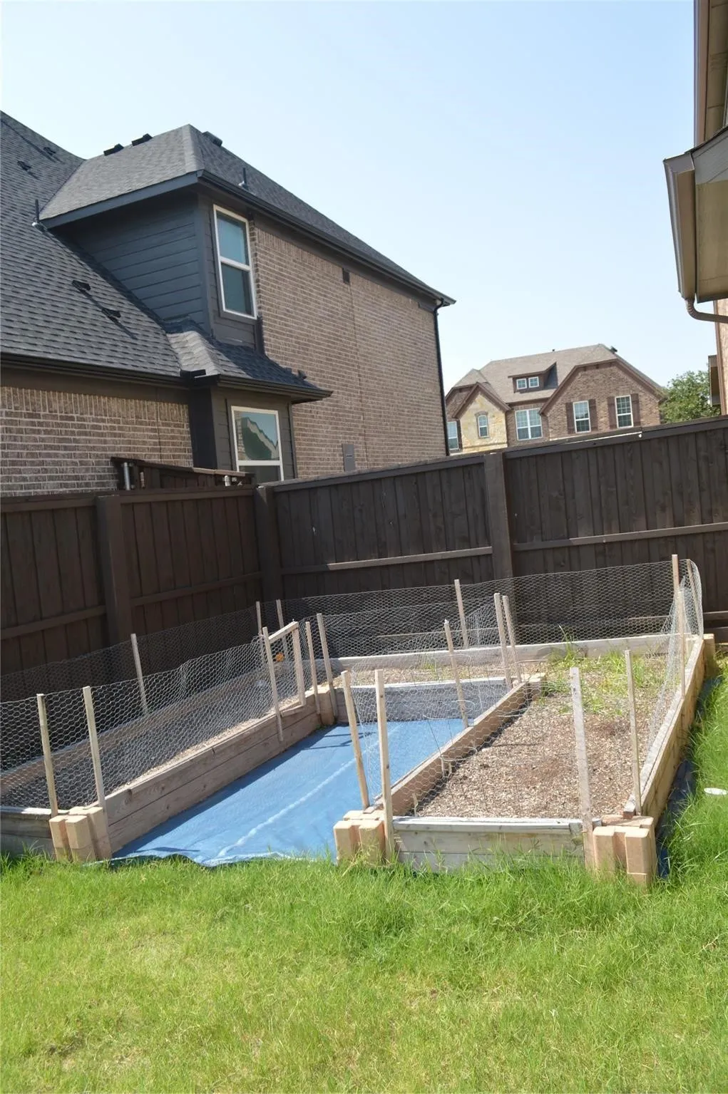 View of pool featuring a garden and a fenced backyard