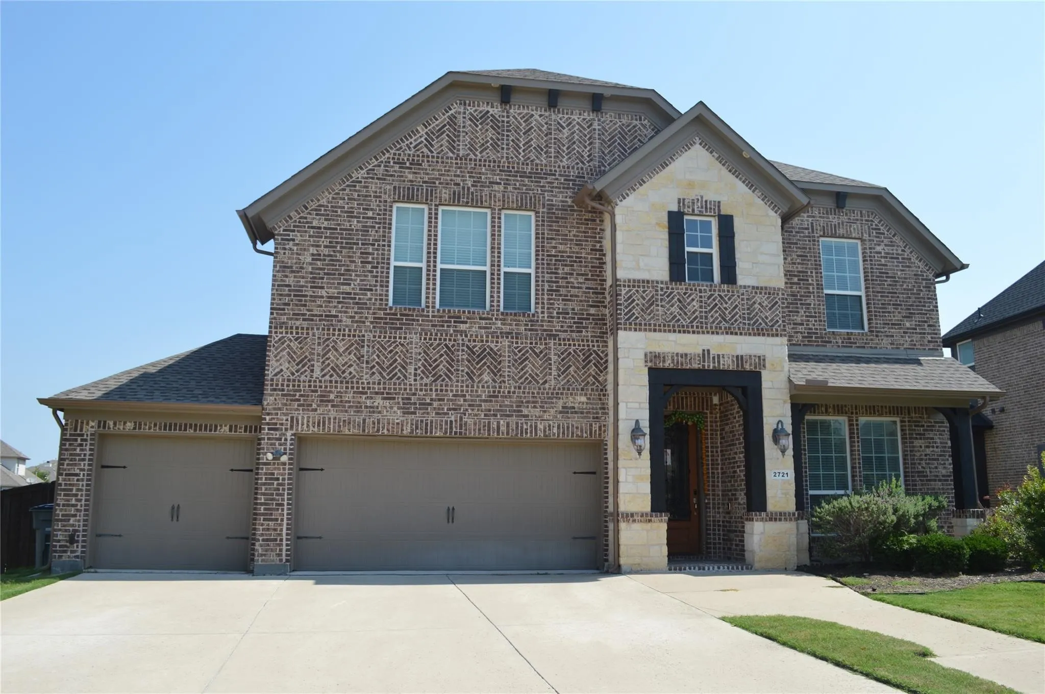 View of front of house featuring brick siding, concrete driveway, a shingled roof, and an attached garage
