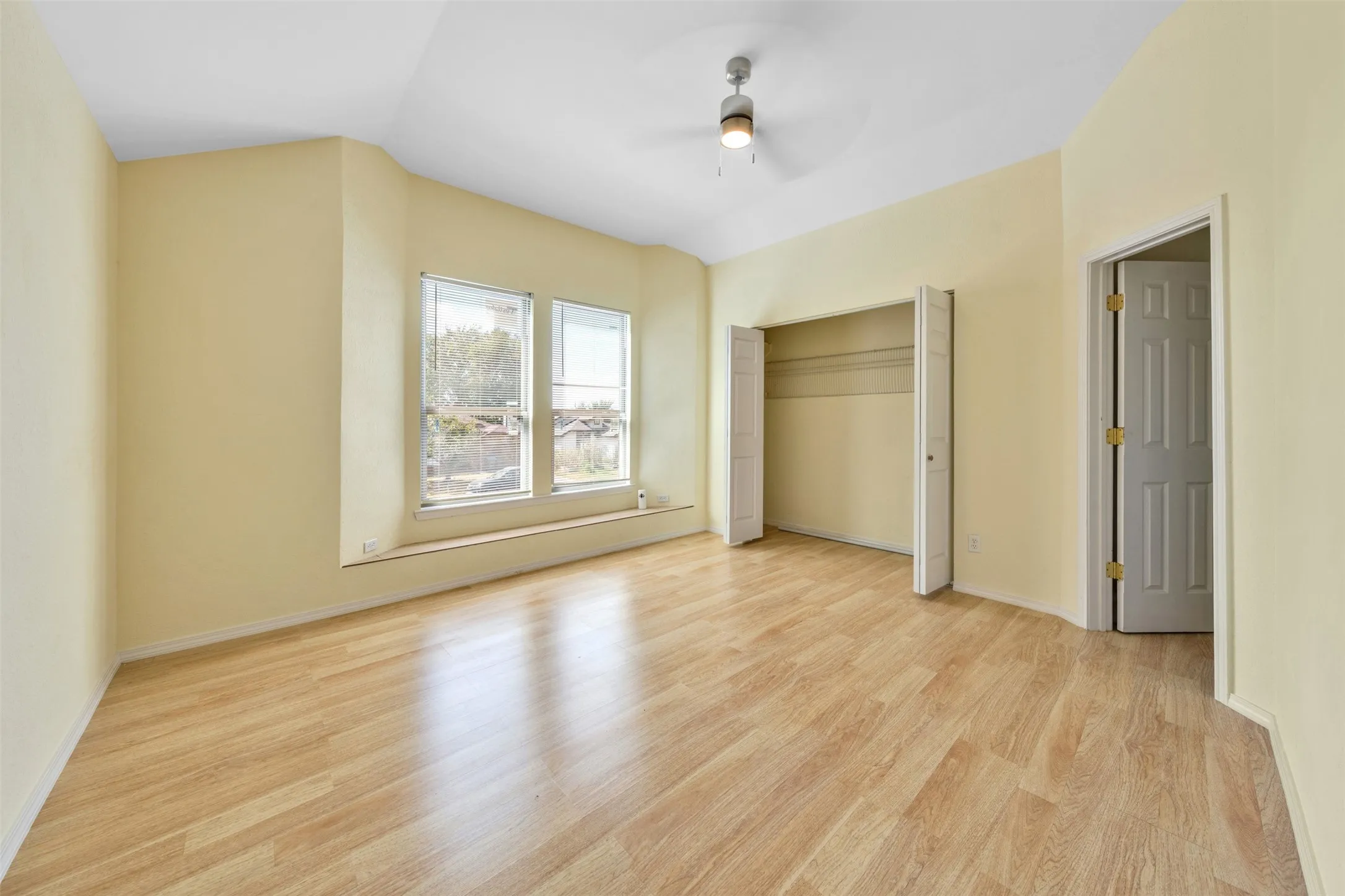 Light wood-finish flooring with a bay window and built-in window seat
