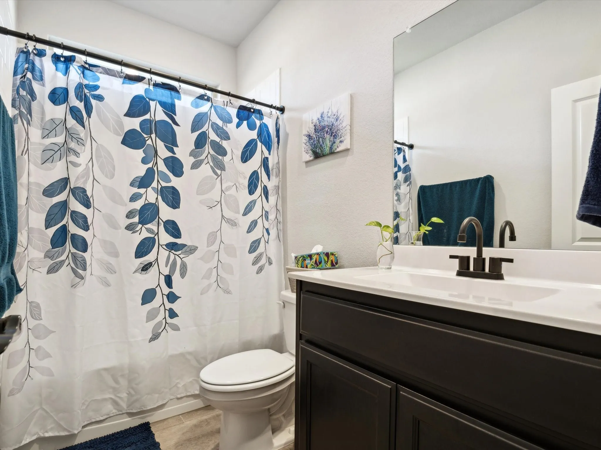 Built-in vanity with a dark wood-finish cabinet, white countertop, and black-finish faucet