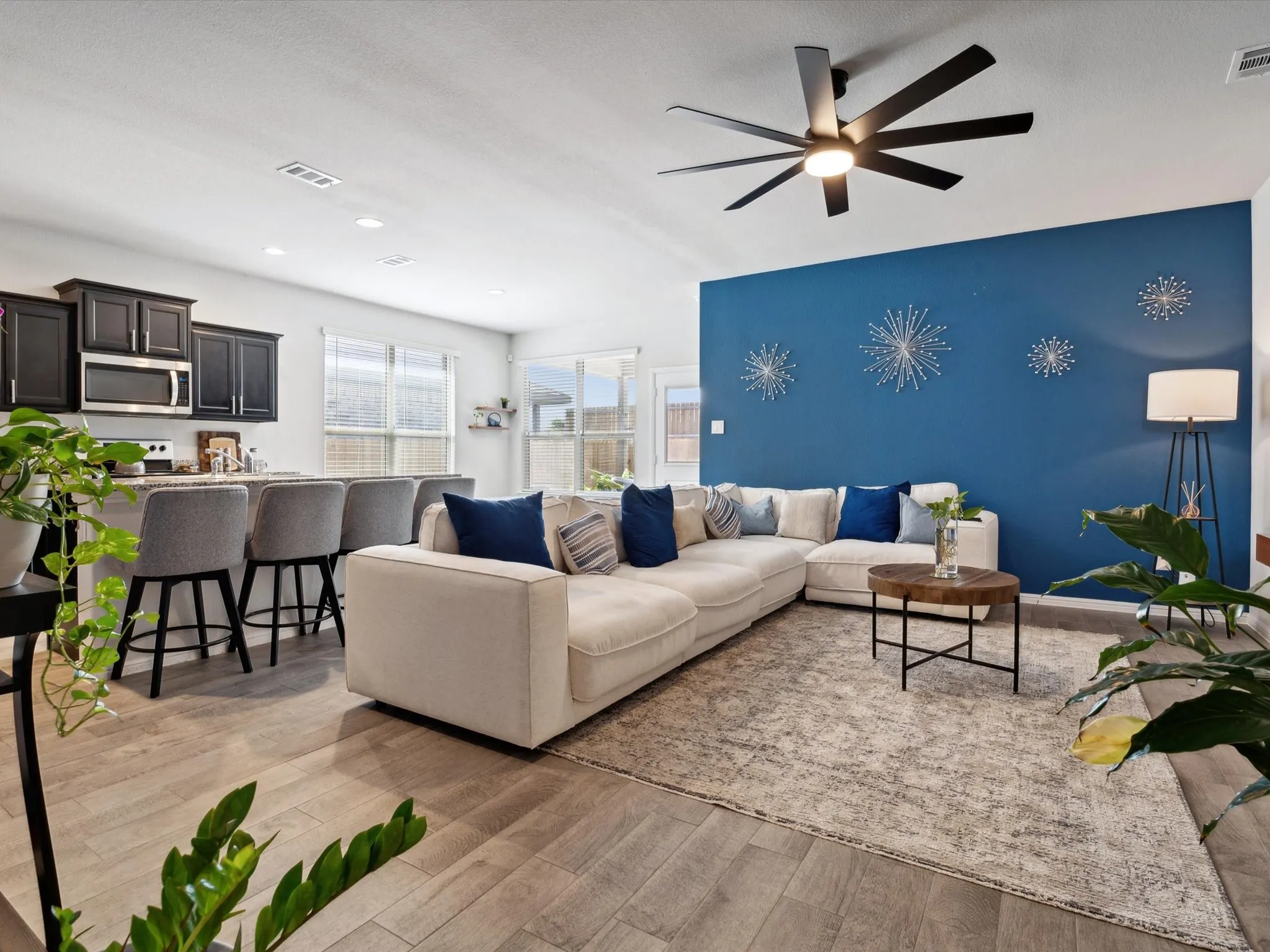 Open-concept living area with wood-finish flooring, a contemporary ceiling fan, and recessed lighting