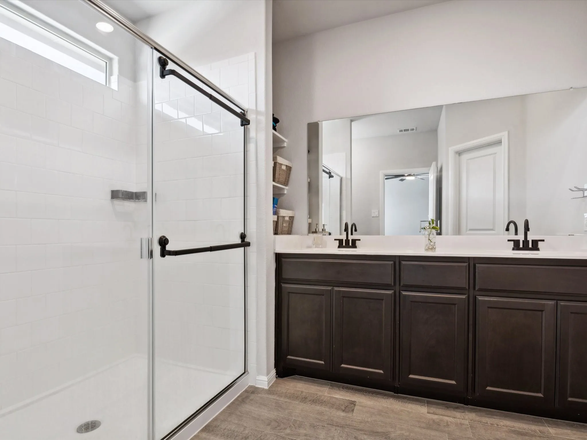 Dual vanity with dark wood-finish cabinetry and black faucets