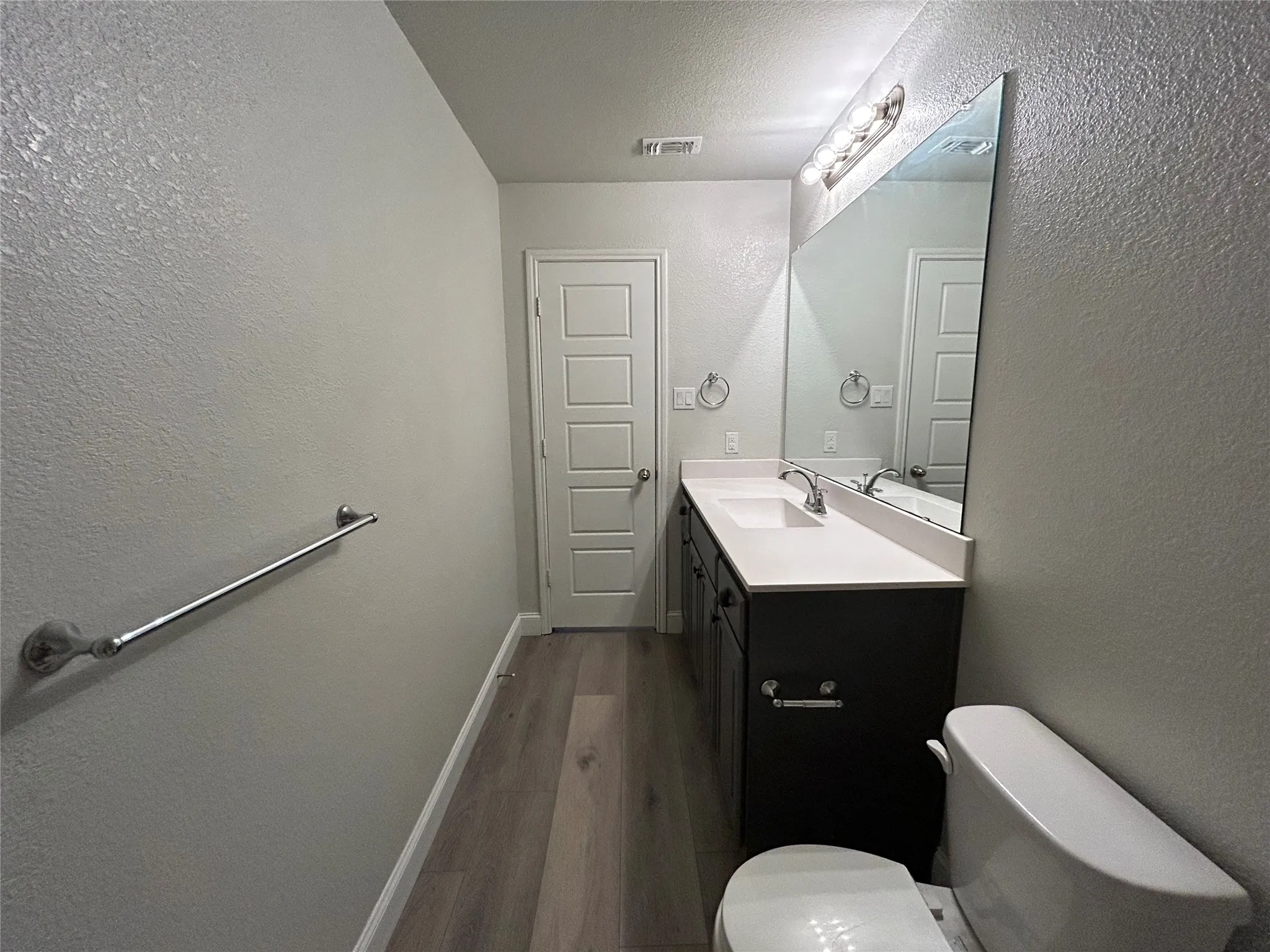 Modern vanity featuring an integrated sink, polished chrome faucet, and expansive wall mirror