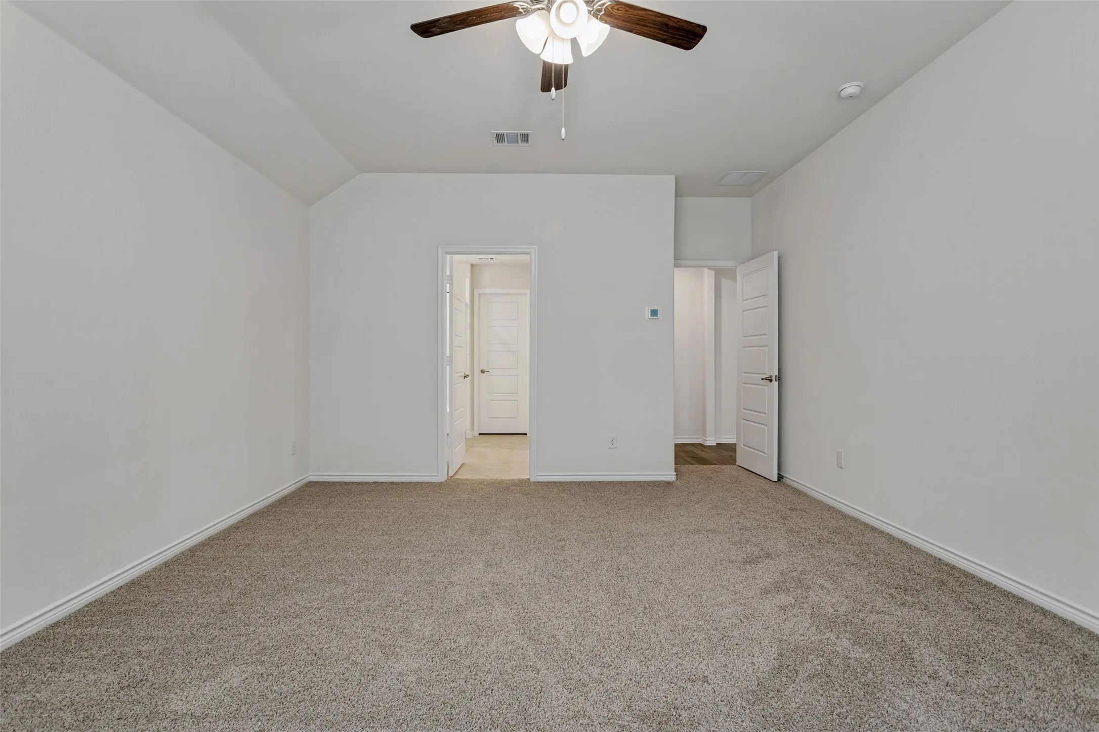 Carpet flooring, ceiling fan with integrated lighting, and white interior doors