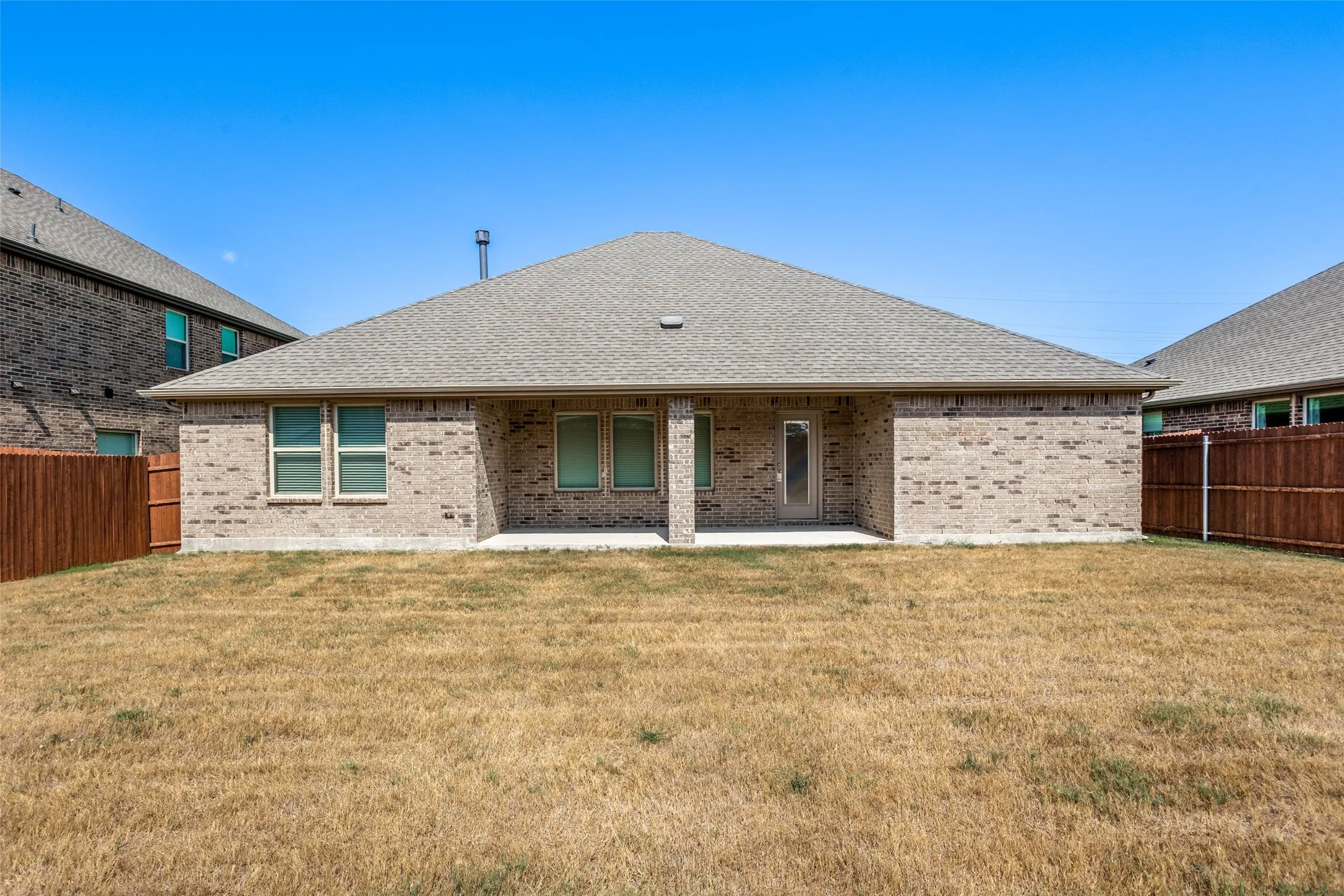 Brick exterior with a gabled roof and a covered patio