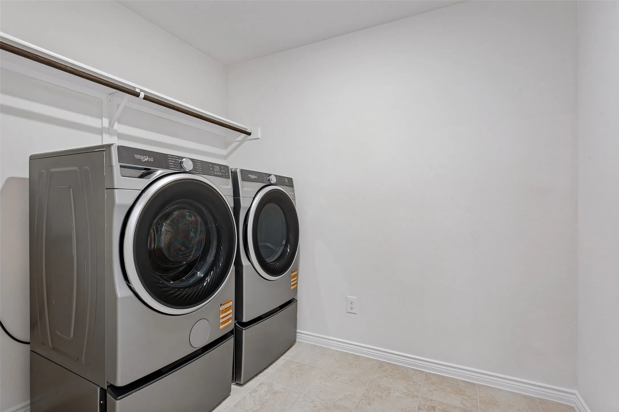 Laundry area featuring a hanging rod and shelving