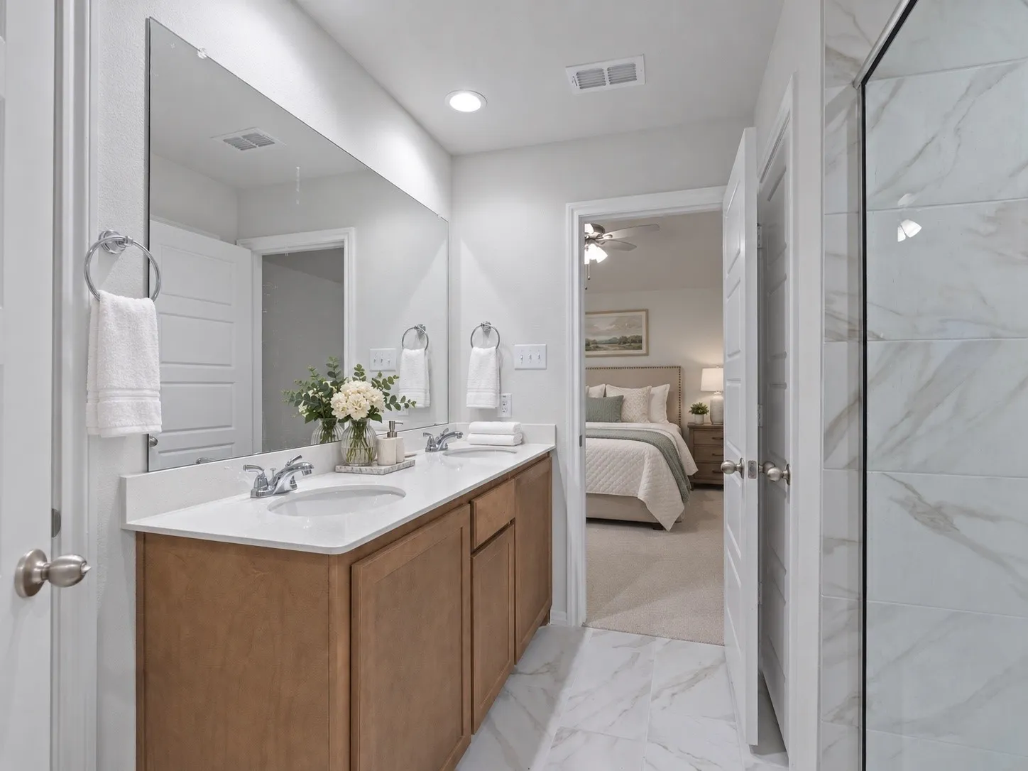 Dual vanity with wood-finish cabinetry, white countertop, and integrated sinks