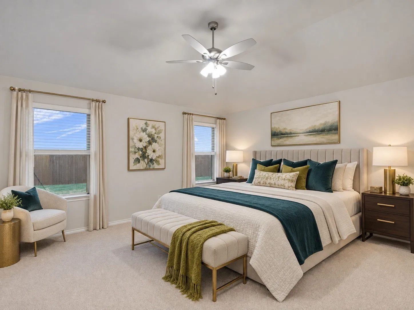 Plush carpeted flooring, two windows with blinds, a ceiling fan with integrated lighting, and a paneled headboard