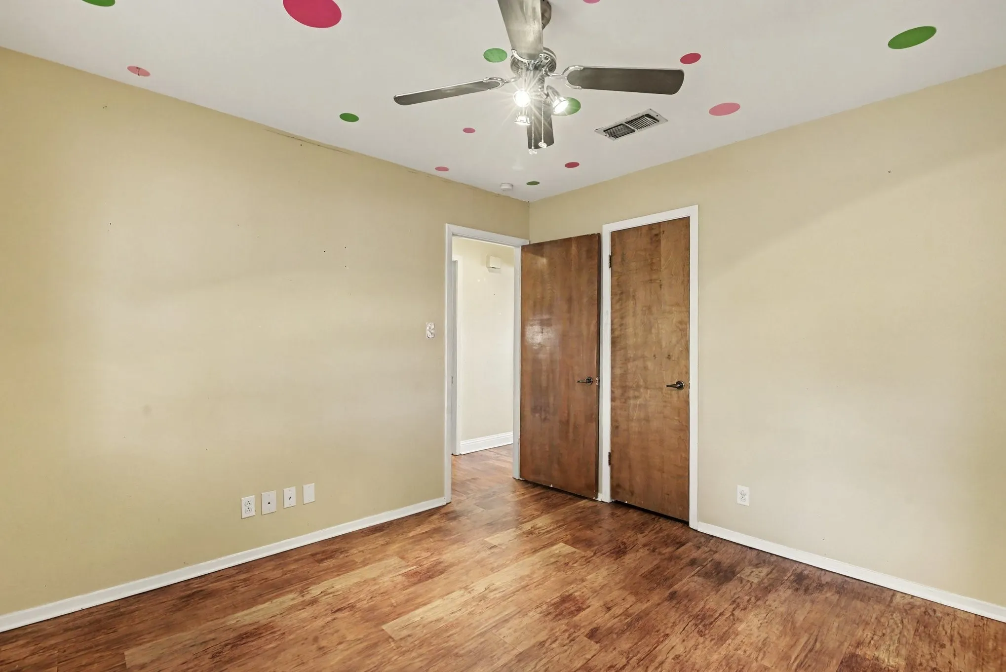 Wood-finish flooring, neutral wall tones, and ceiling fan with integrated lighting
